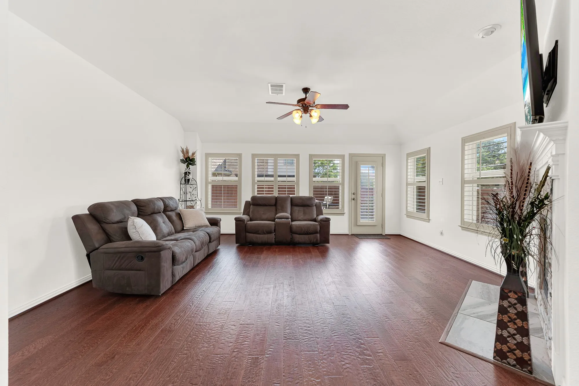 The spacious family room is designed for comfortable everyday living and effortless entertaining. Rich hardwood floors and a wall of windows overlooking the backyard fill the space with abundant natural light.