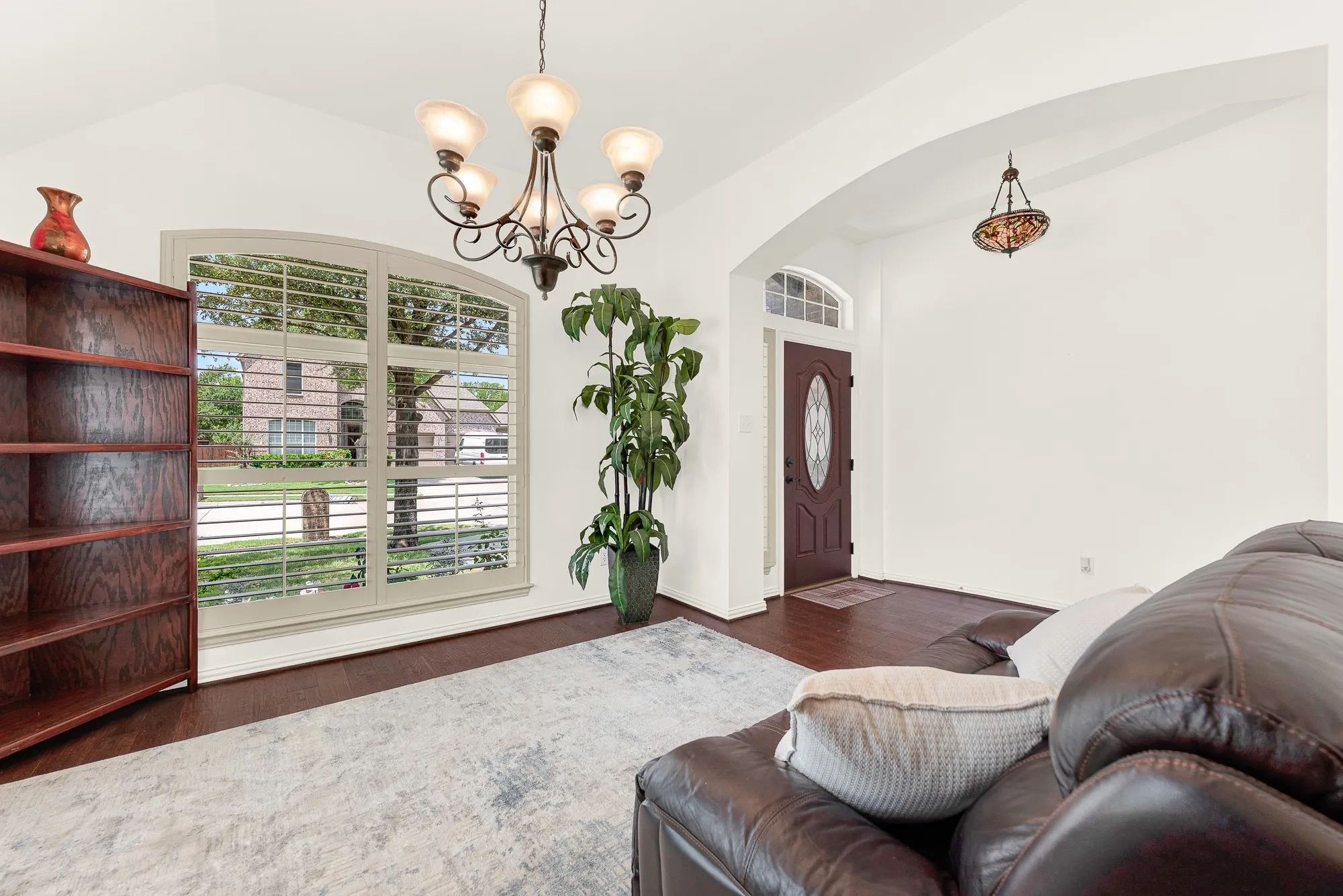 The oversized arched window and classic chandelier bring character and warmth to this versatile room just off the entry. It's easy to imagine catching up with friends here before dinner or enjoying a quiet afternoon away from the main living areas.