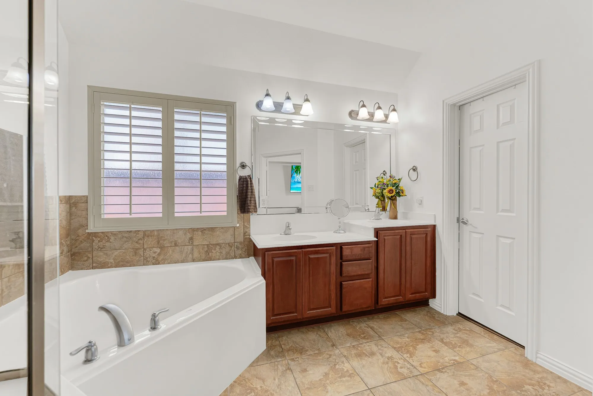 A long vanity offers generous counter space, while the oversized walk-in closet provides exceptional storage and organization. Enjoy a space where everything has its place, making busy mornings feel effortless.
