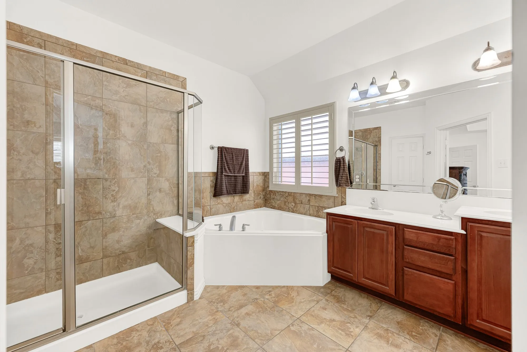 The ensuite bath features a large walk-in shower, soaking tub, dual vanities, and abundant counter space for easy everyday living. Enjoy a quiet evening soak or get ready for the day with plenty of room to move around.