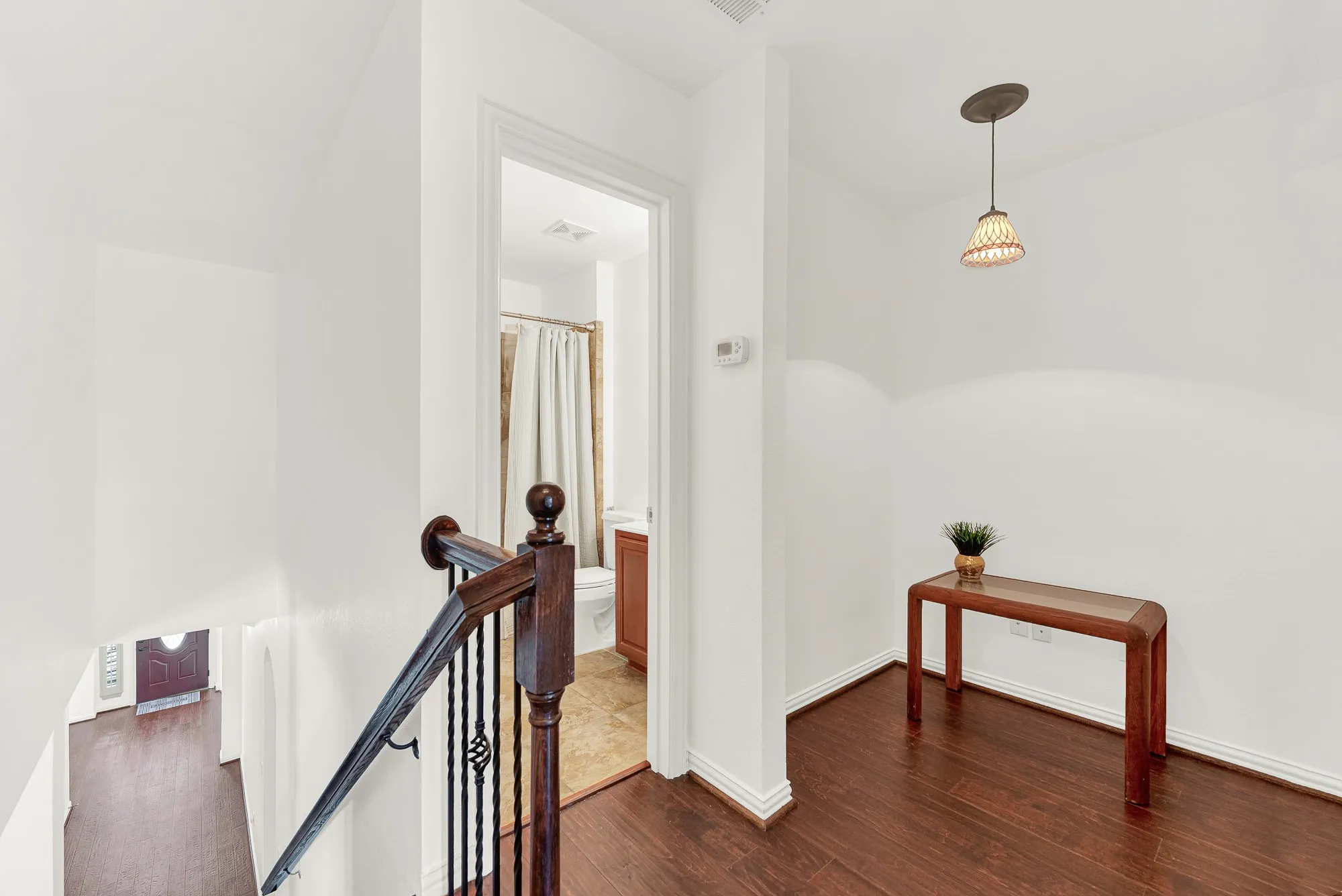 The upstairs landing creates a welcoming transition to the private suite and includes space for a small desk, reading nook, or decorative console. The nearby full bathroom adds convenience while maintaining separation from the main living spaces below.