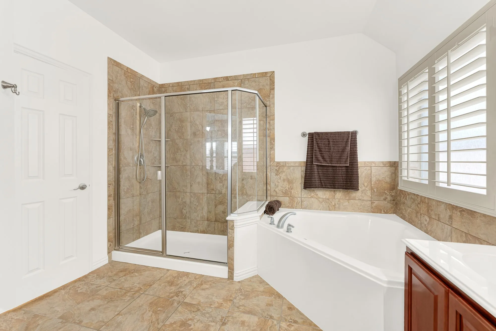 The oversized walk-in shower and soaking tub create a spa-inspired setting designed for both comfort and convenience. Whether you're getting ready for the day or enjoying a quiet evening, this bathroom offers the space to do it with ease.
