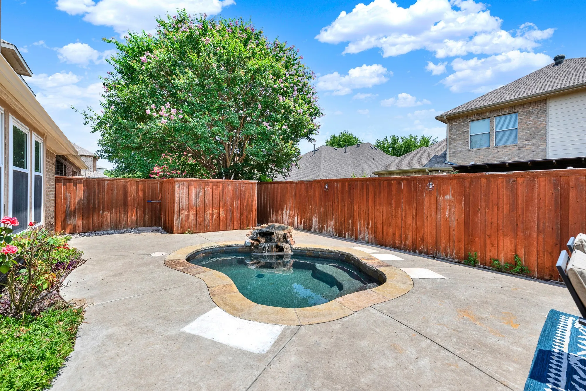 A cascading rock waterfall adds soothing movement to the spa, creating a peaceful focal point in the backyard. Imagine cooling off on a warm afternoon or unwinding beneath the stars after a busy day.