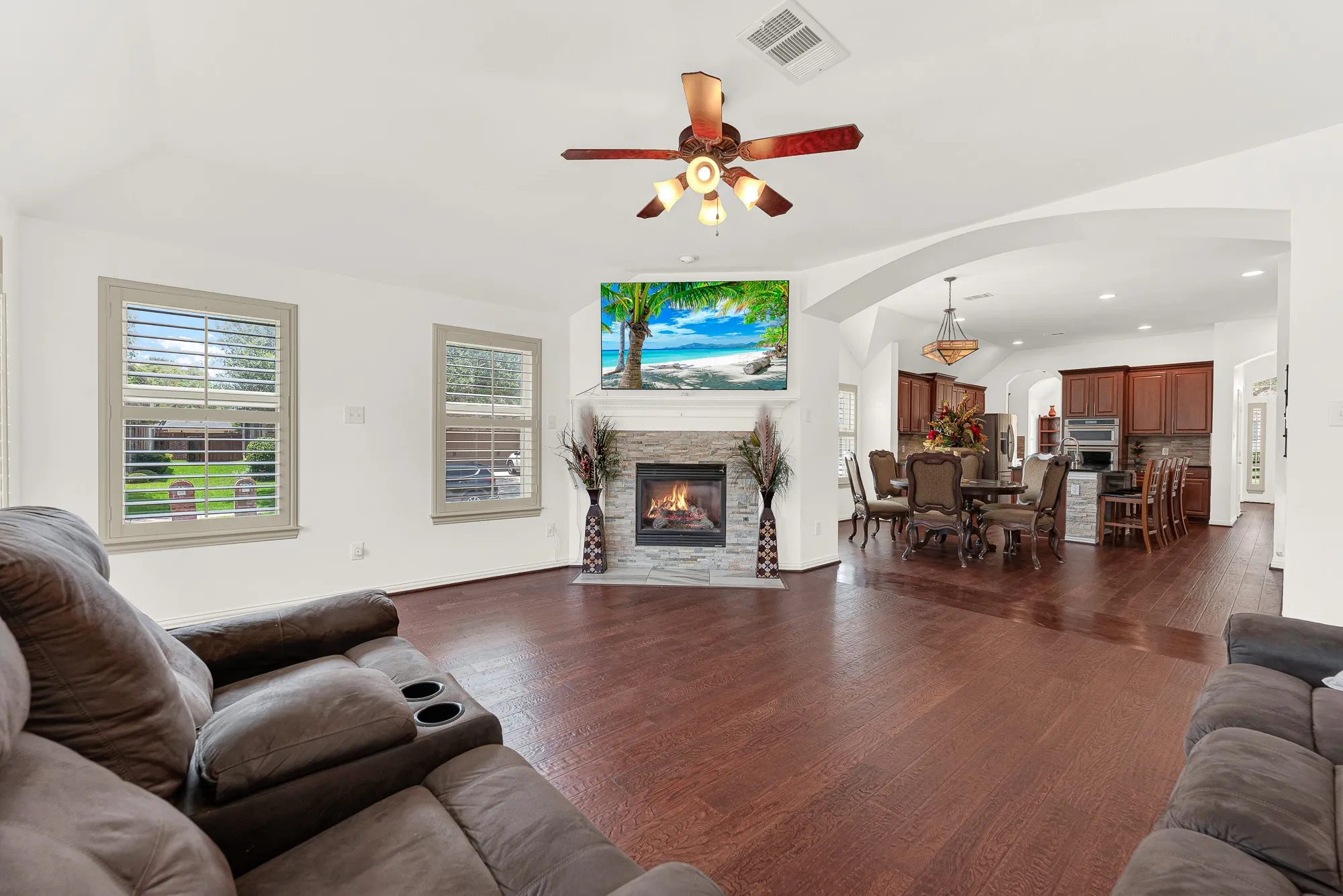 The spacious living room is filled with natural light from several large windows and flows effortlessly into the dining area and kitchen, creating an open, connected layout. Whether hosting holiday gatherings or enjoying everyday family time, everyone can stay together without feeling crowded.