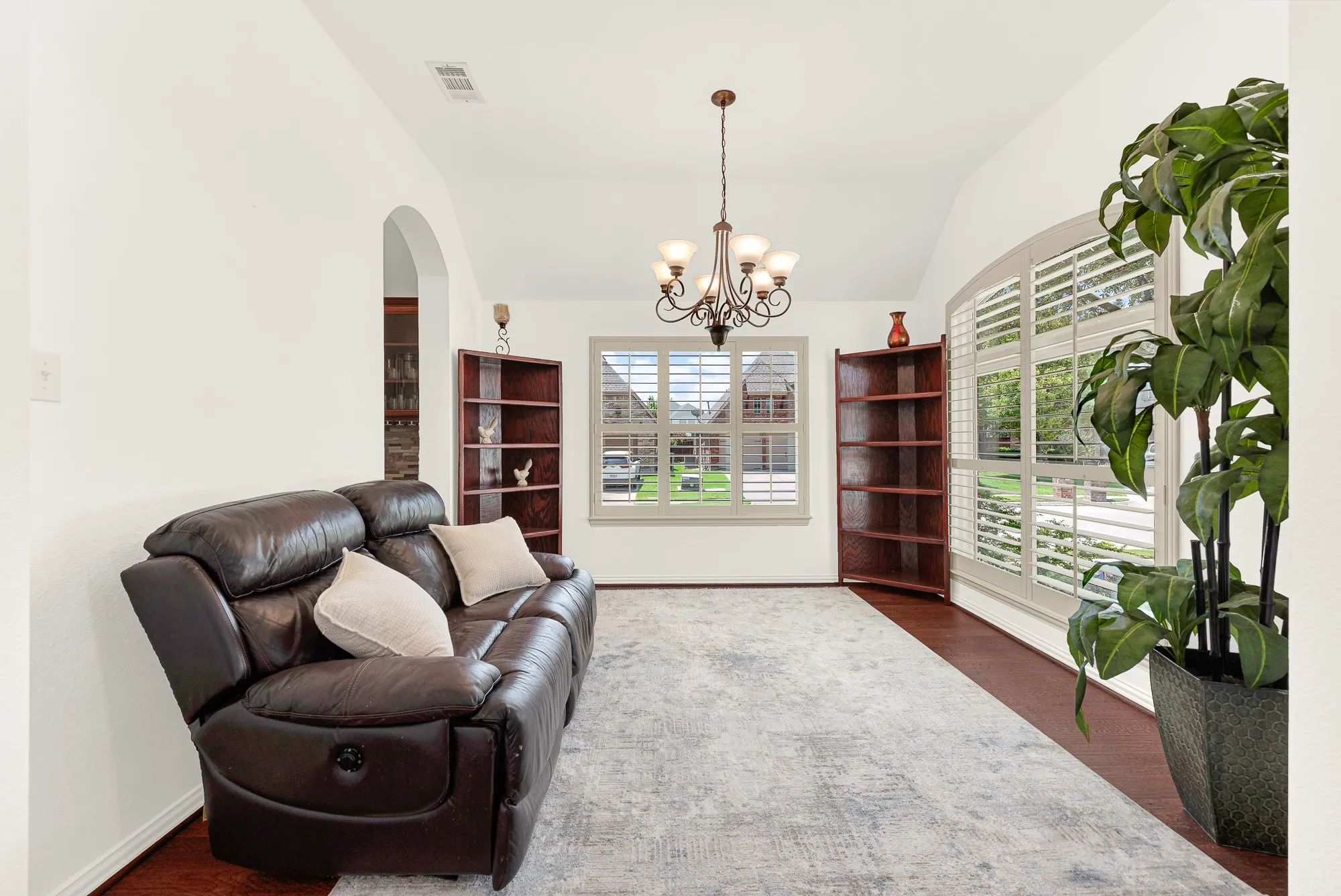 Expansive front-facing windows and rich wood flooring give this flexible space an open, airy feel with beautiful neighborhood views. Picture it as a peaceful reading room, music space, or stylish home office filled with daylight.
