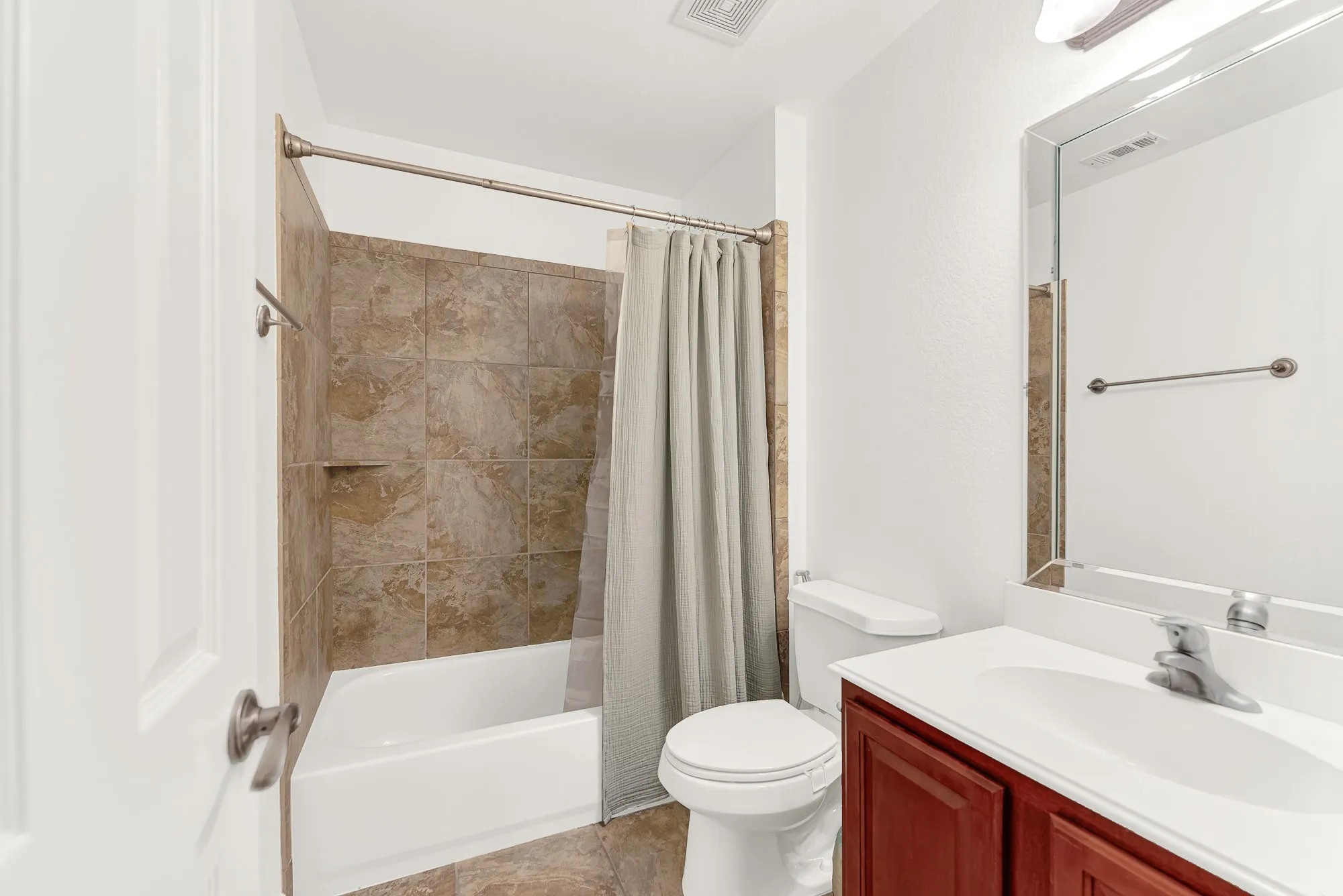 The private upstairs full bathroom features a tub/shower combination with tile surround, spacious vanity, and neutral finishes. Conveniently located adjacent to the upstairs bedroom, it completes this versatile living area, making it perfect as a private guest suite, teen retreat, or mother-in-law accommodations.