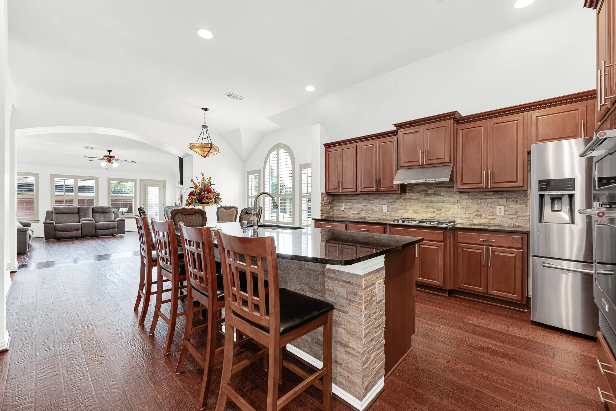 A vaulted ceiling and wide-open layout connect the kitchen, dining, and living spaces, creating an airy atmosphere filled with natural light. Gather around the island while conversations easily flow from meal prep to movie night.