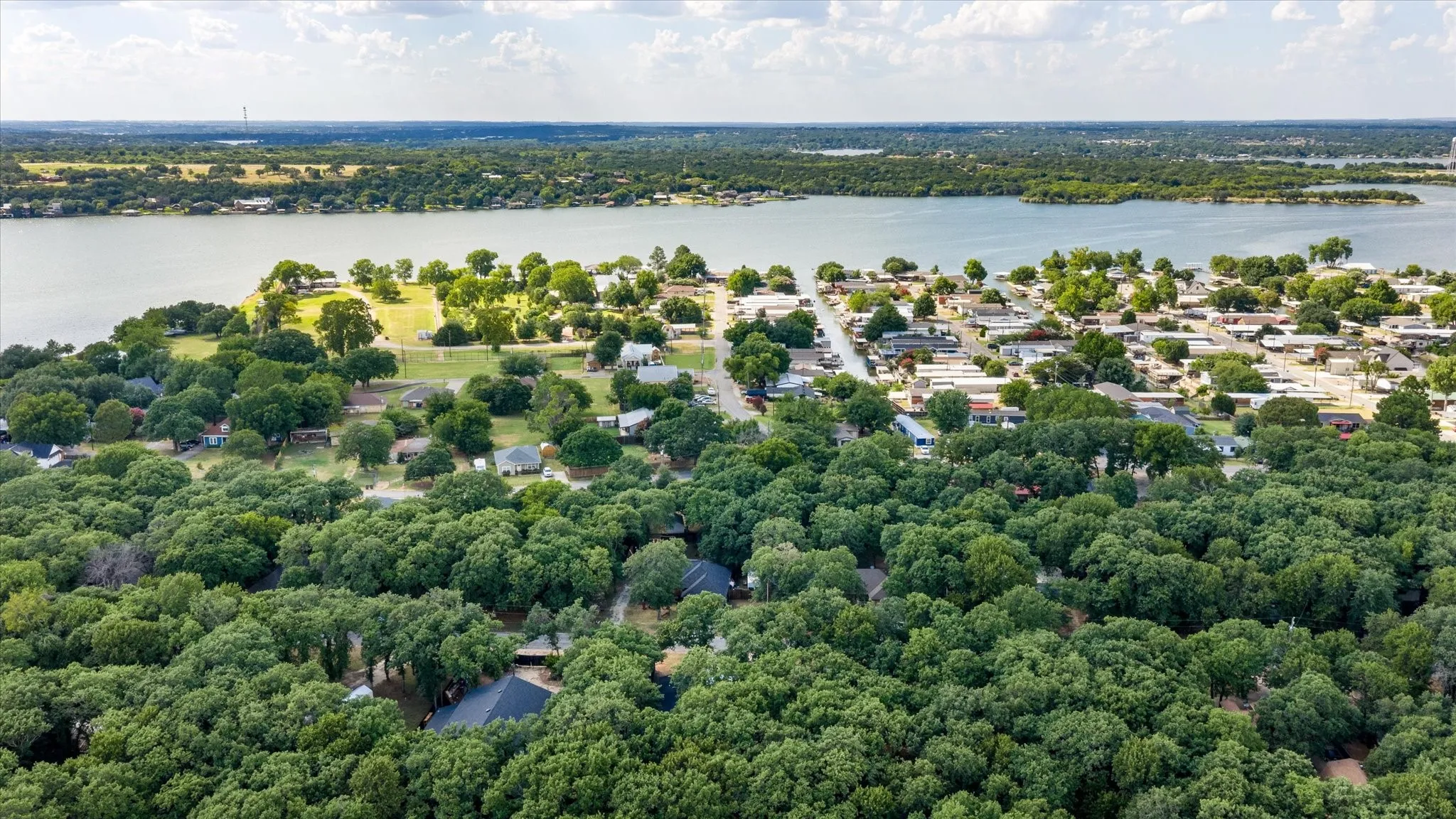 4617 Lyndi Ln
Granbury, TX  76049 Aerial perspective showcasing a waterfront community with extensive tree coverage