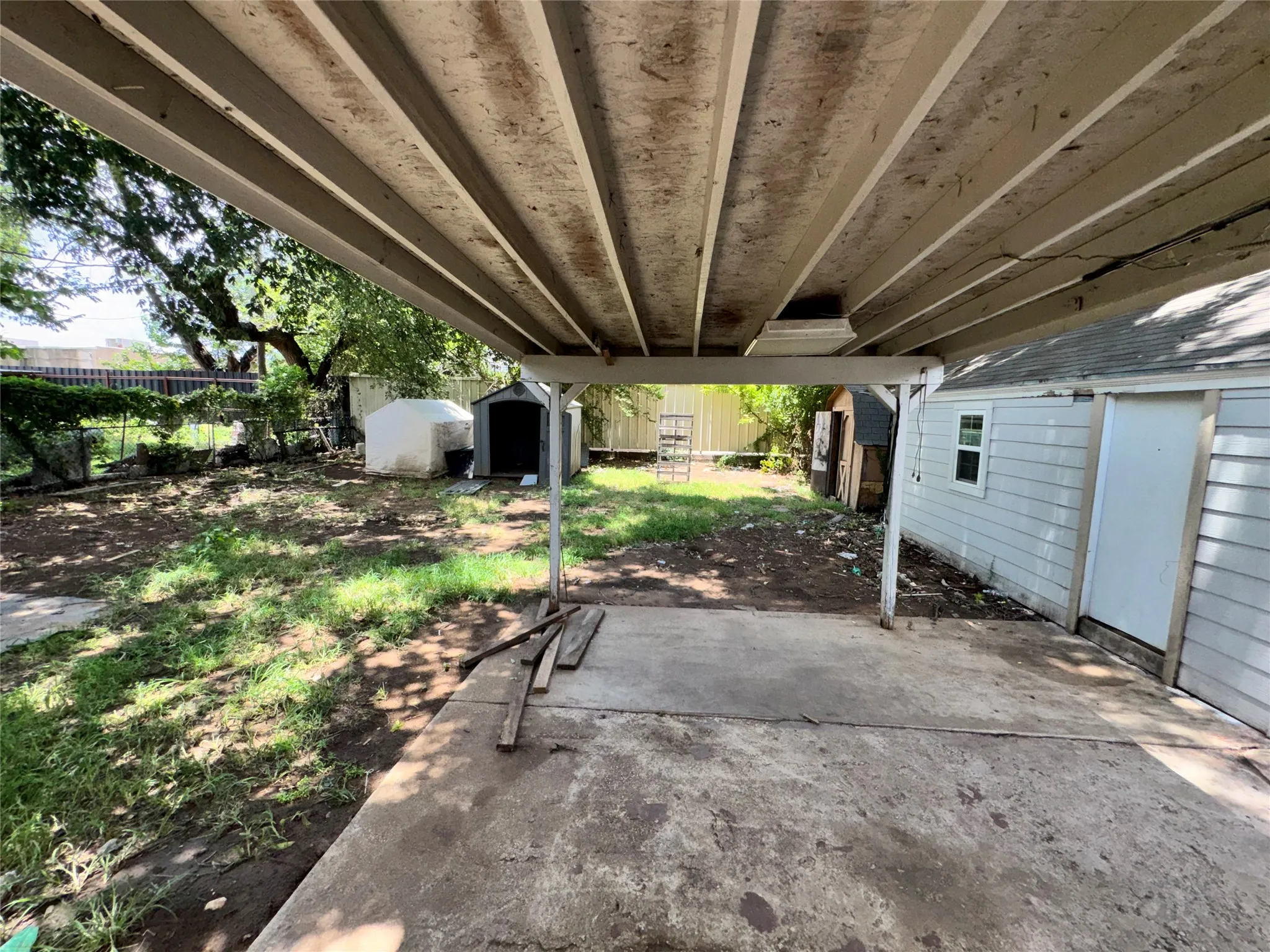 Covered patio area with a concrete slab, offering direct access to the backyard
