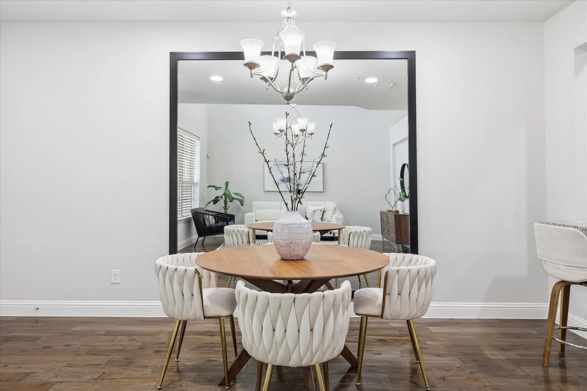Formal dining space featuring wood-finish flooring, white baseboards, and a chandelier with glass shades
