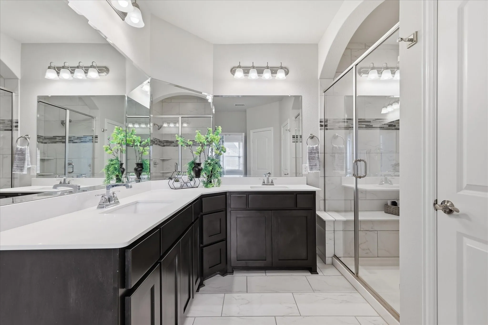 Dual sink vanity with dark wood-finish cabinetry and white countertops