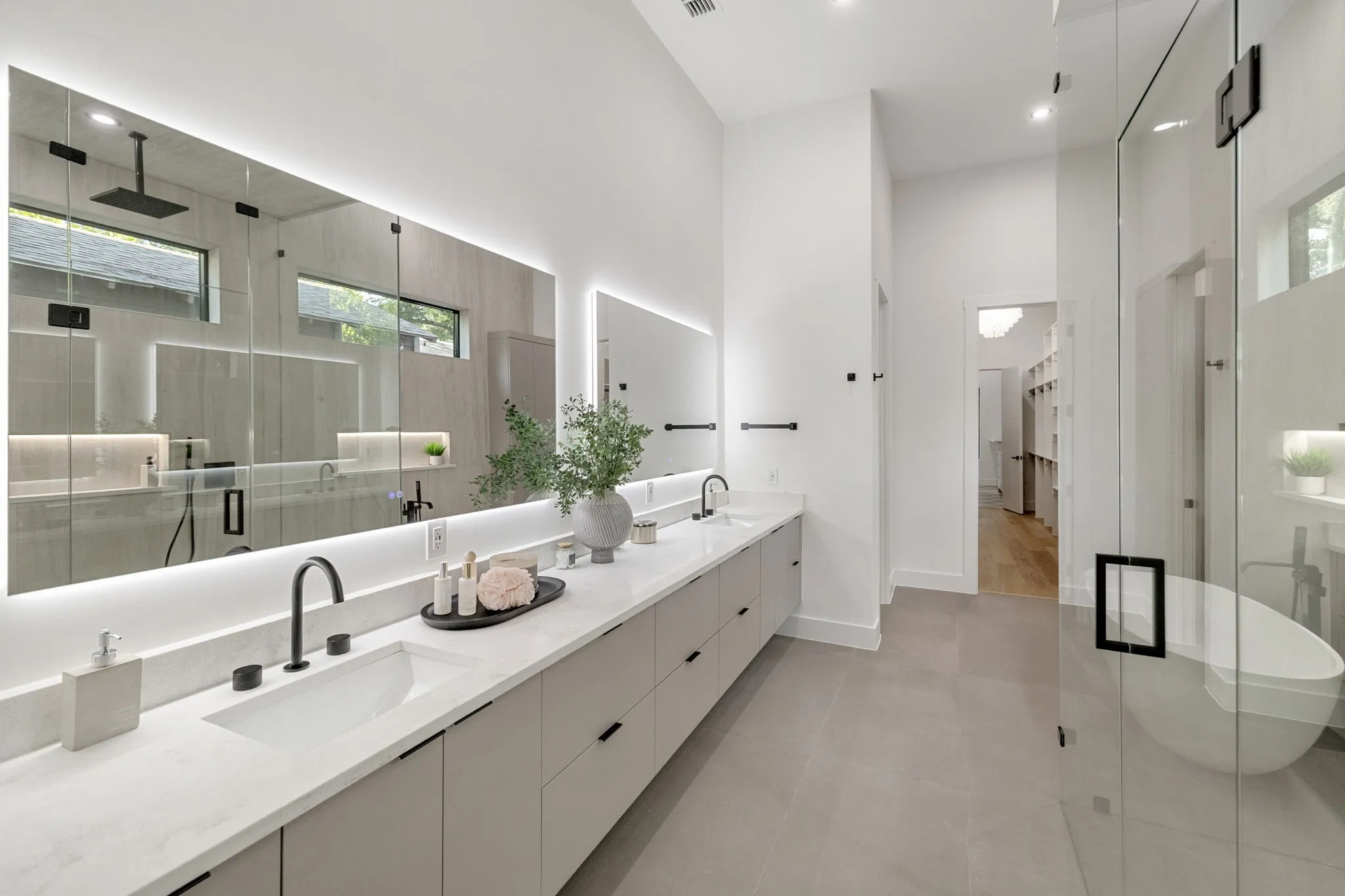 Contemporary bathroom featuring an expansive dual vanity with integrated sinks and matte black fixtures