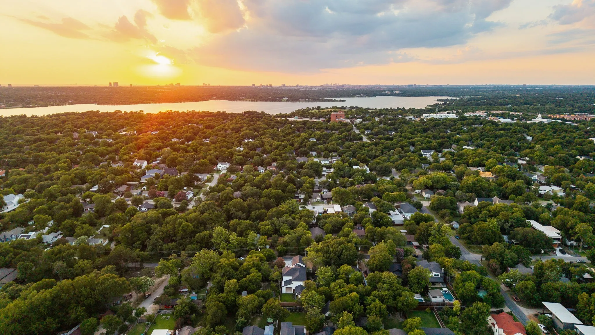 Aerial perspective showcasing an expansive residential area with abundant mature trees and homes with various roof styles