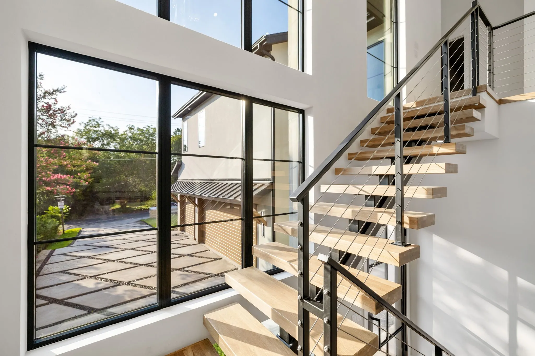Floating wood-finish staircase with cable railing system