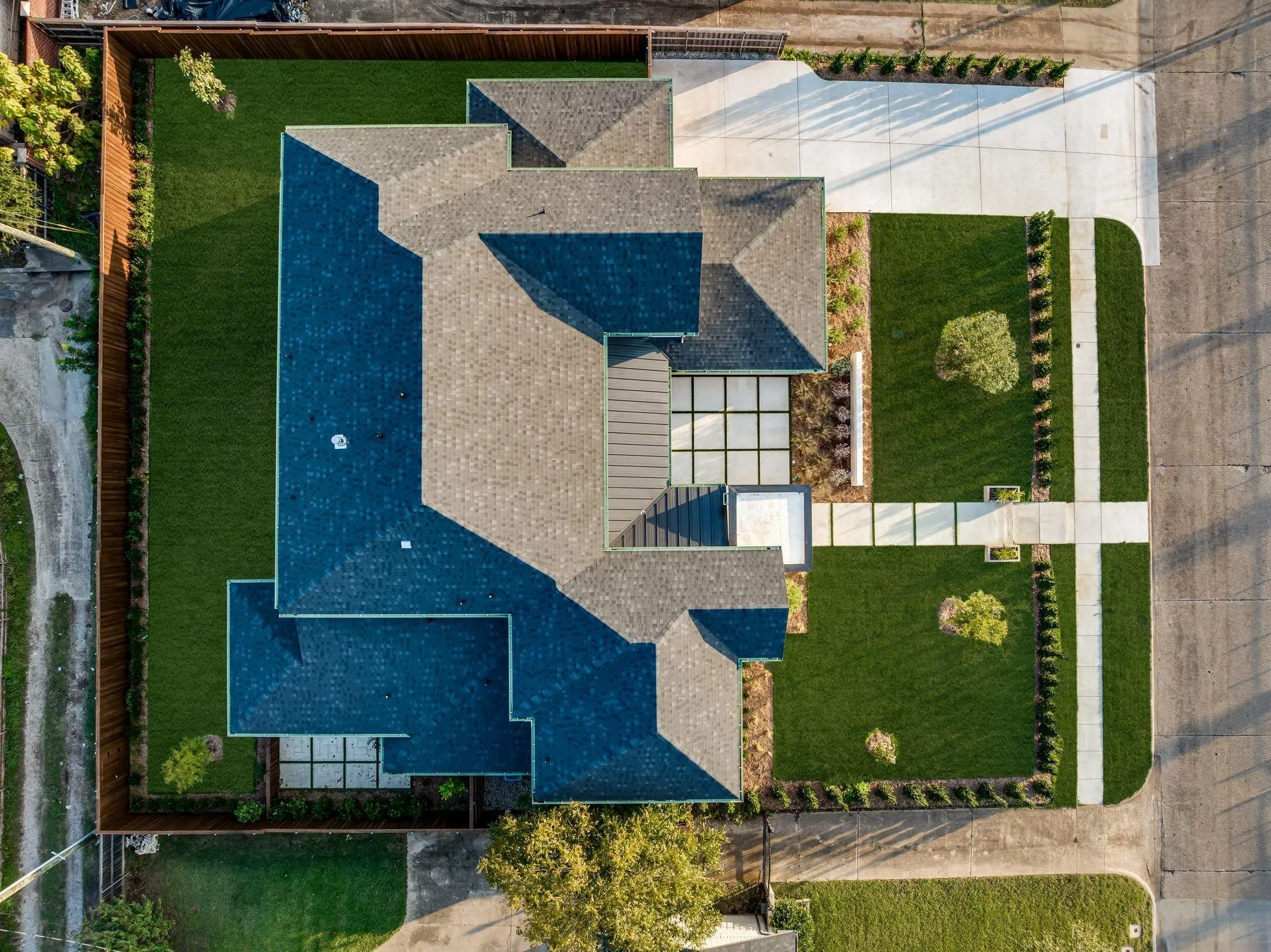 Expansive property featuring a multi-gabled roofline, concrete driveway, and a meticulously manicured lawn