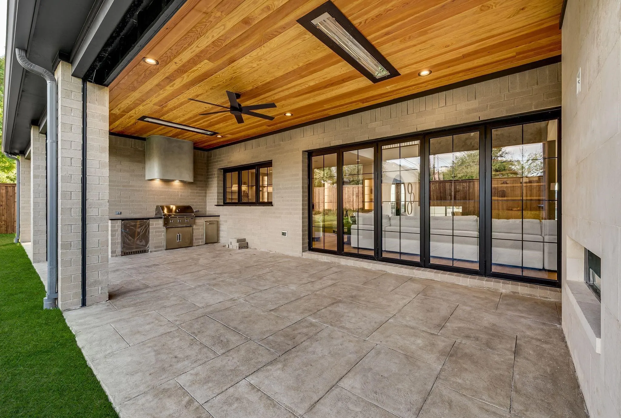 Expansive covered patio featuring a wood-panel ceiling with recessed lighting and a ceiling fan