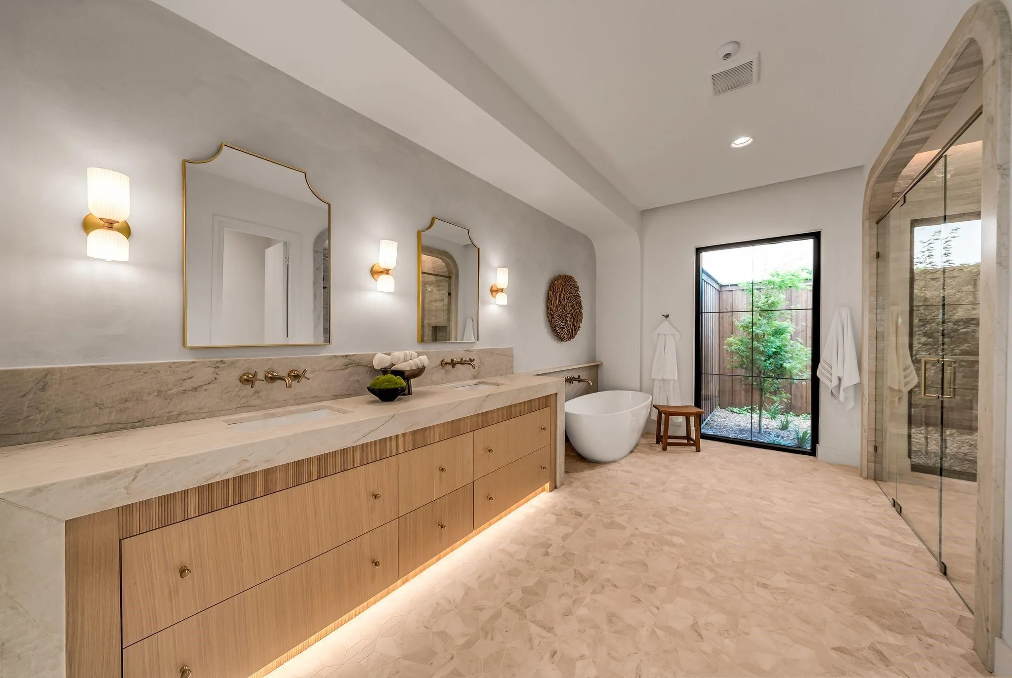 Contemporary bathroom featuring a freestanding soaking tub, a spacious walk-in shower with glass enclosure, a dual vanity with undermount sinks, integrated countertop, and wood-finish cabinetry