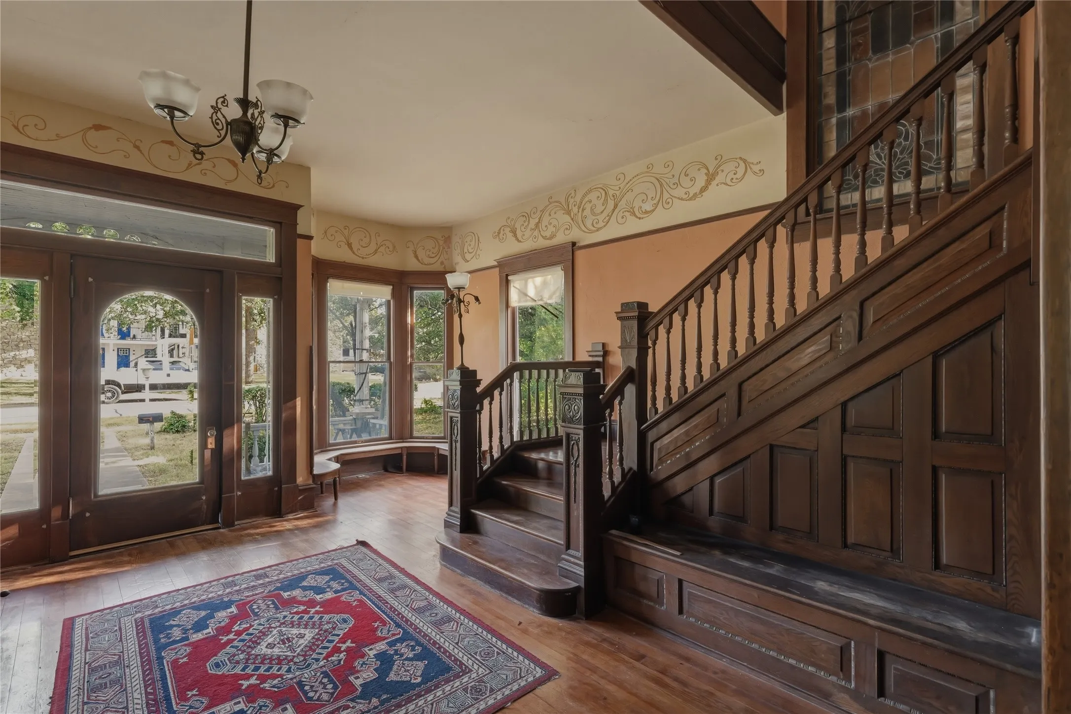Entryway with original hardwoods and intricate staircase