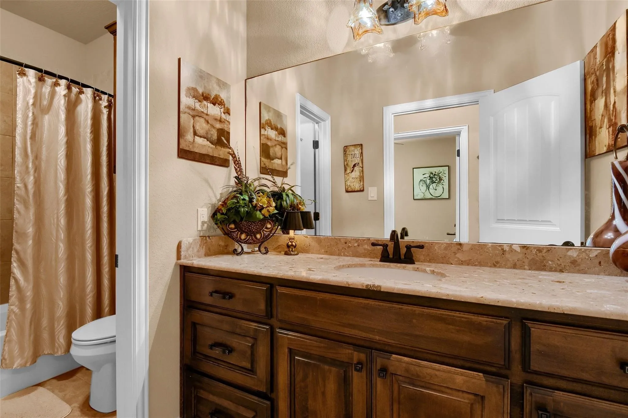 Bathroom featuring a dark wood-finish vanity with ample storage, an integrated sink, and a light-toned countertop