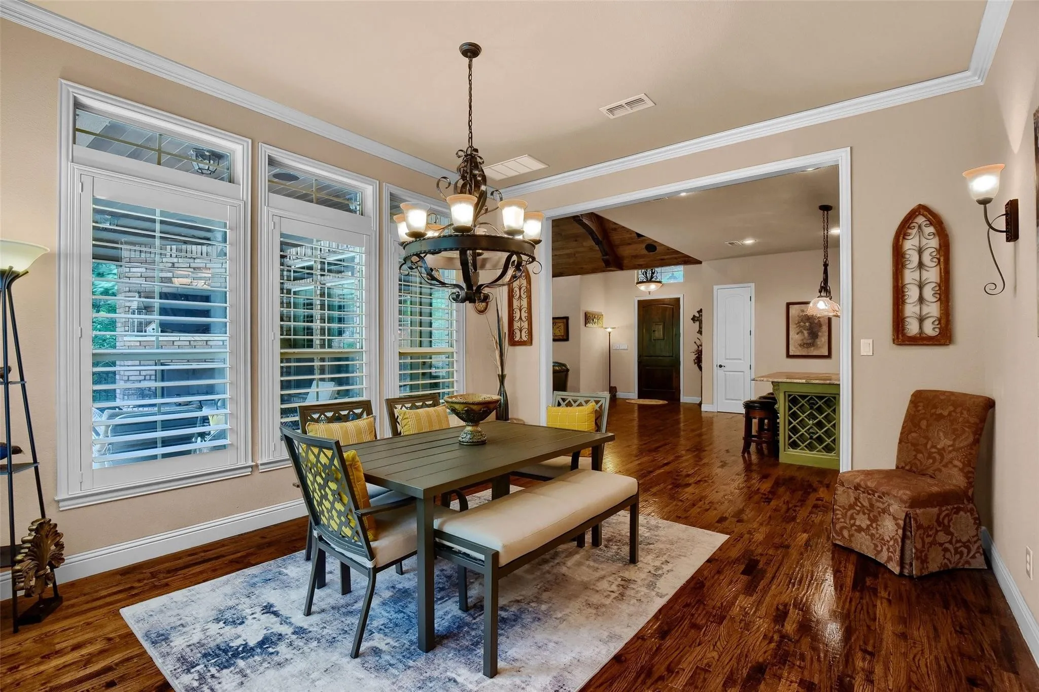 Dining area featuring hardwood flooring, a decorative chandelier, and an arched entryway