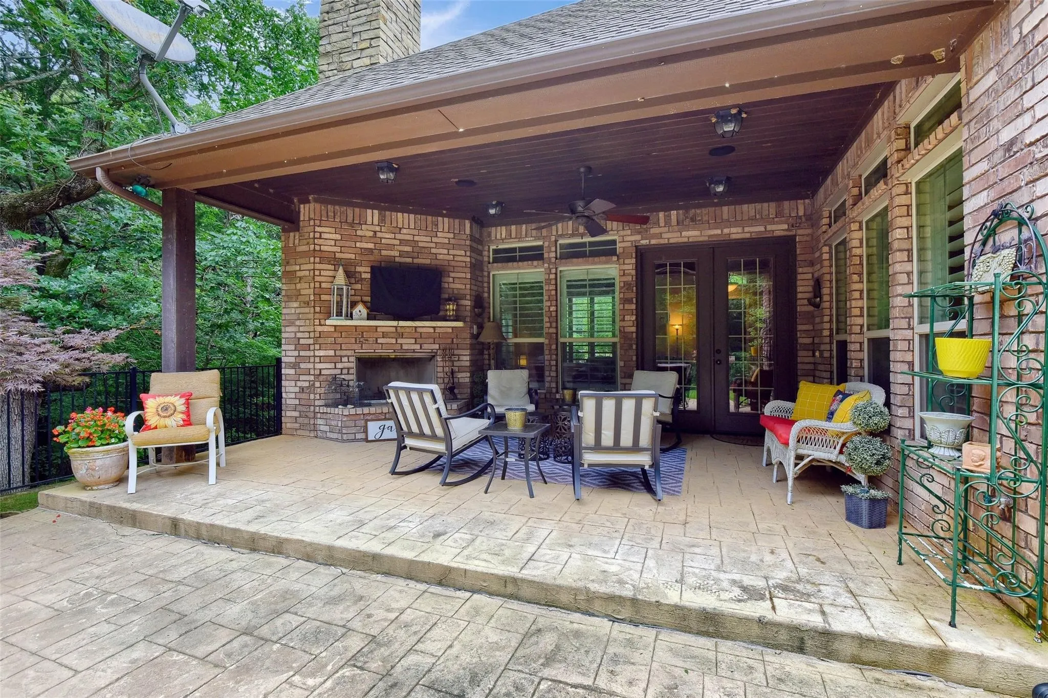 Covered patio featuring an outdoor brick fireplace with hearth, a ceiling fan, and recessed lighting
