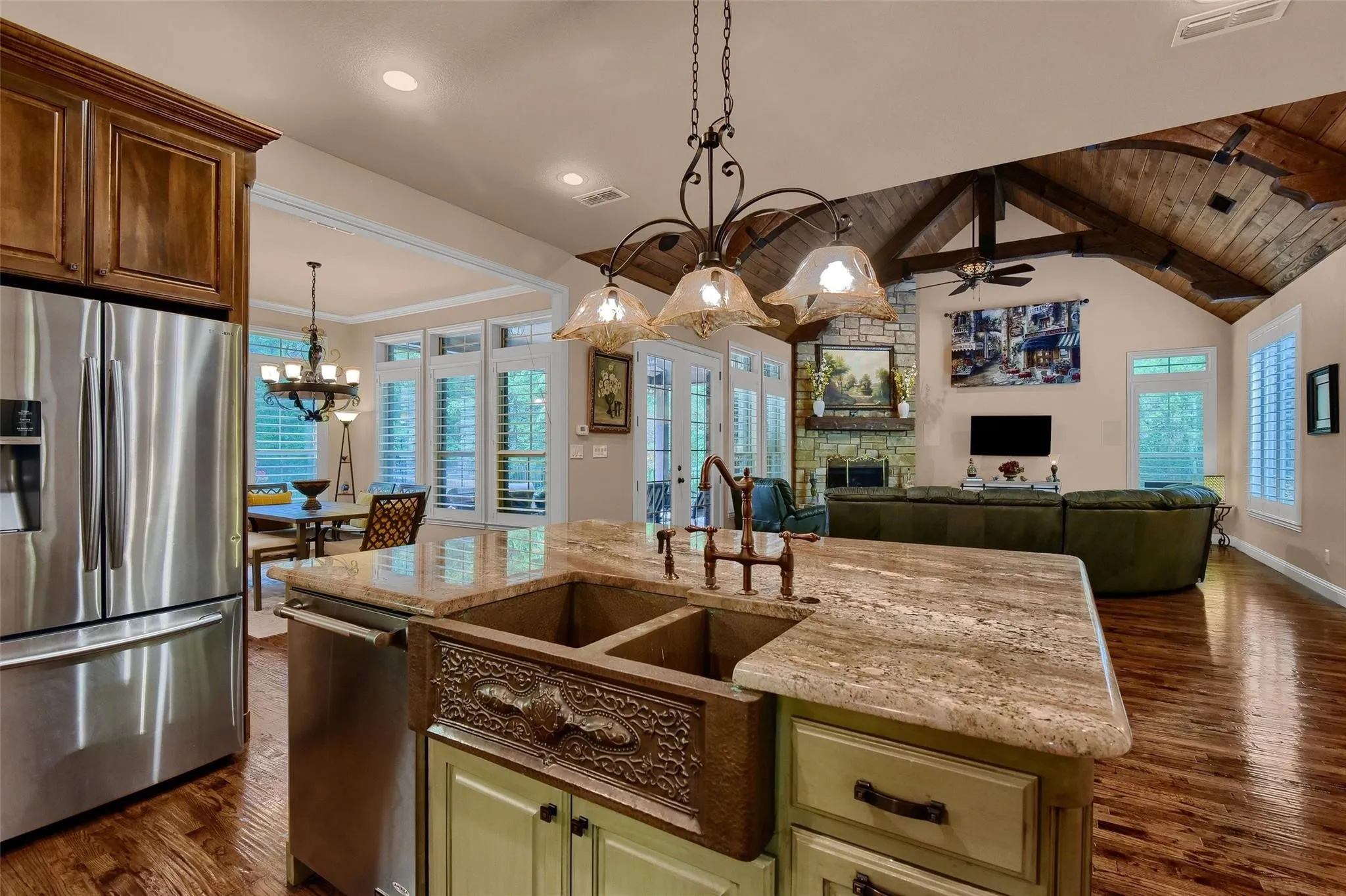 Kitchen island featuring a double basin copper farmhouse sink, light-toned countertop, and bronze faucet