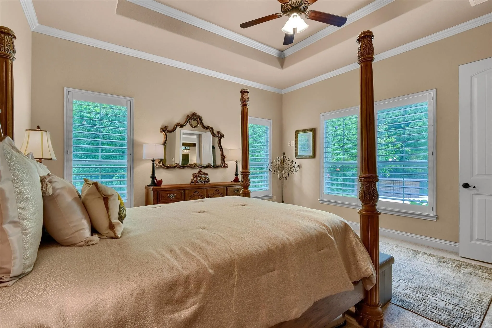 Tray ceiling with crown molding and a ceiling fan light fixture