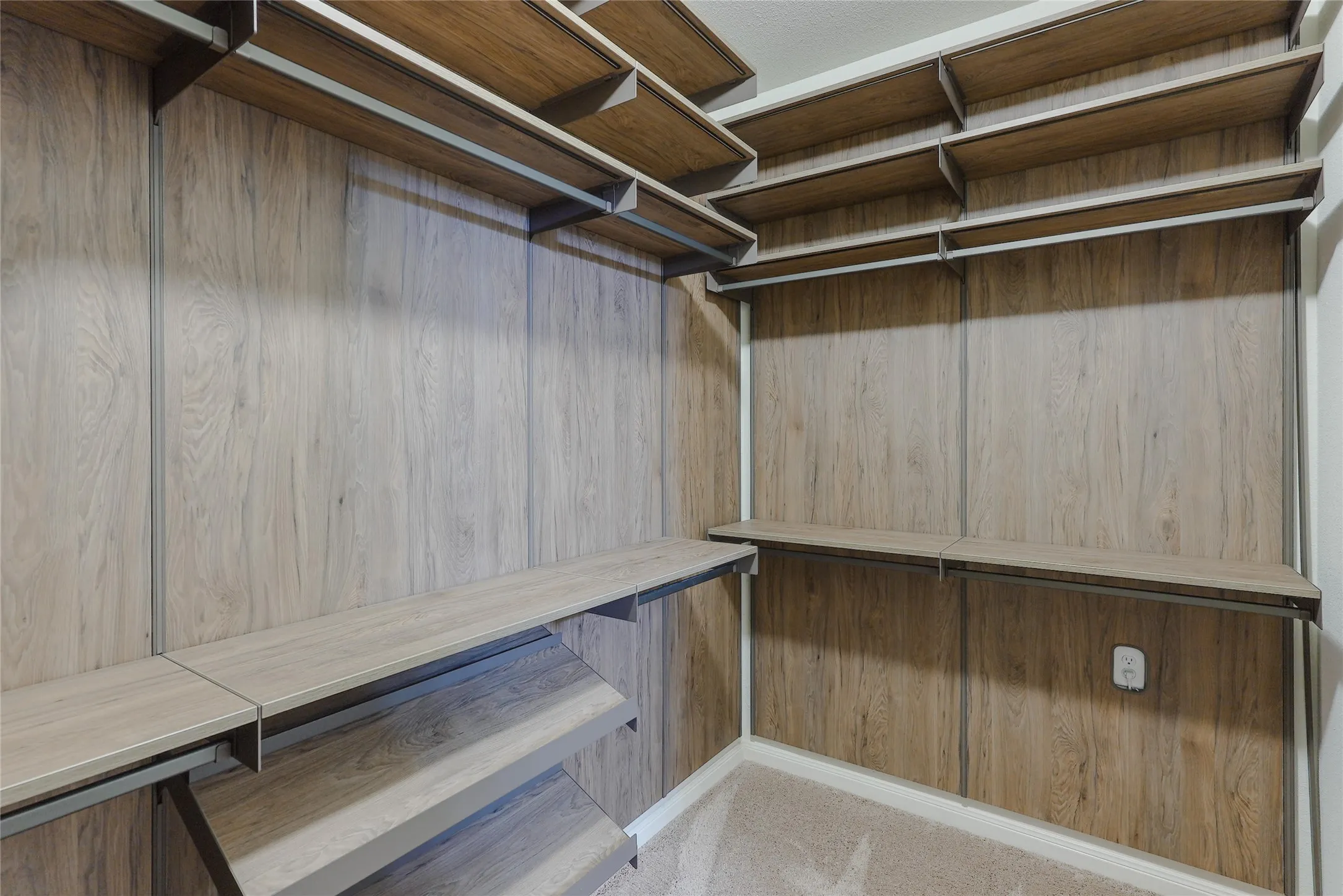 Custom closet system featuring wood-finish shelving and paneling