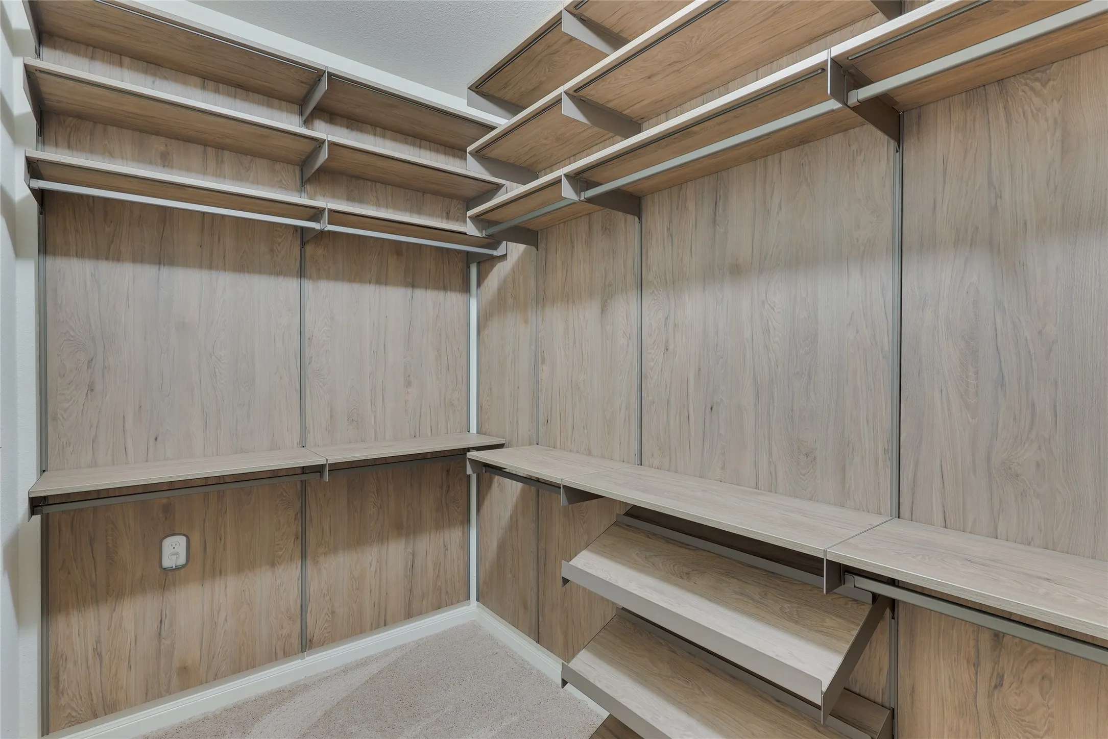 Custom closet system featuring light wood-finish shelving and hanging rods