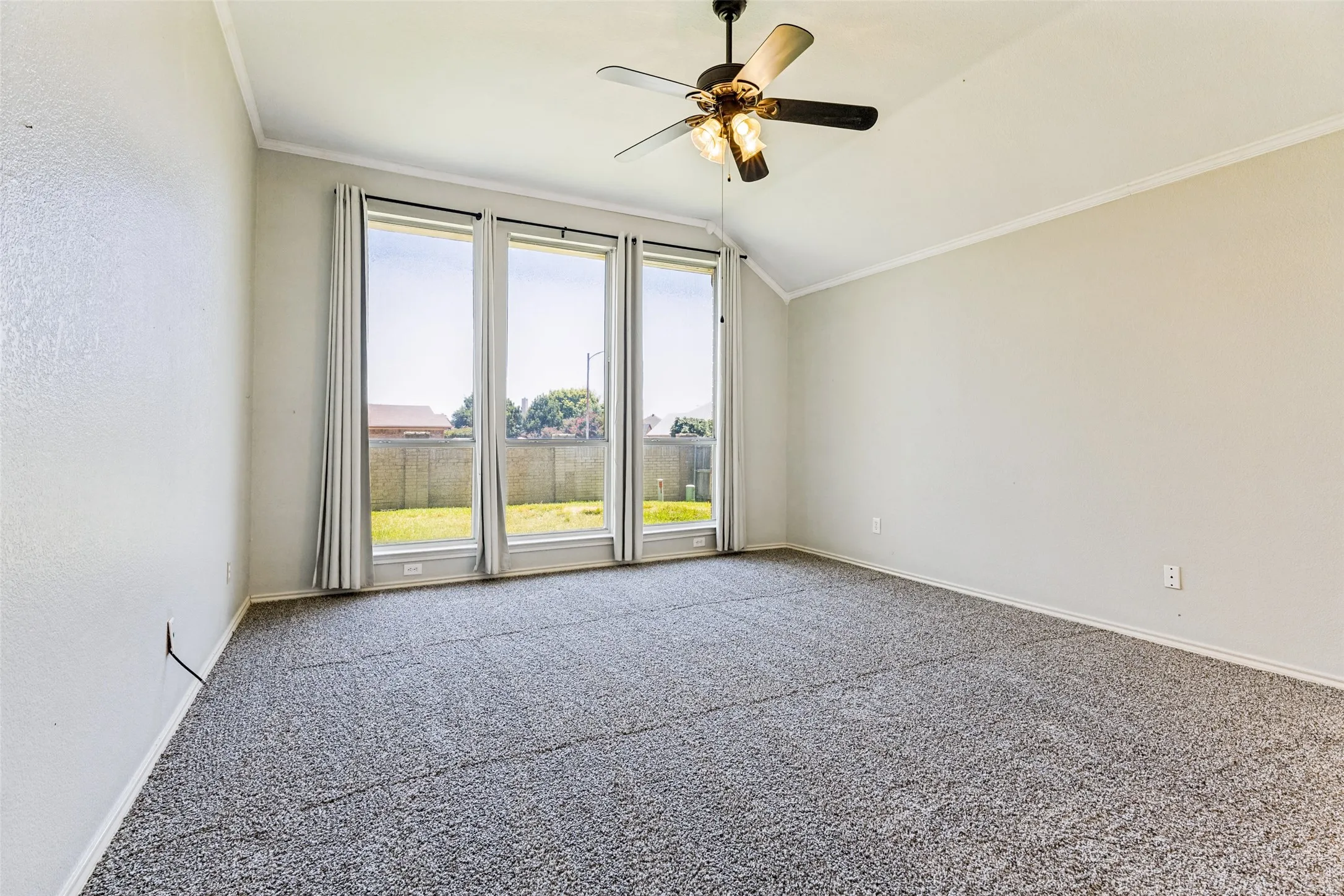 Room featuring a vaulted ceiling and a ceiling fan with integrated lighting