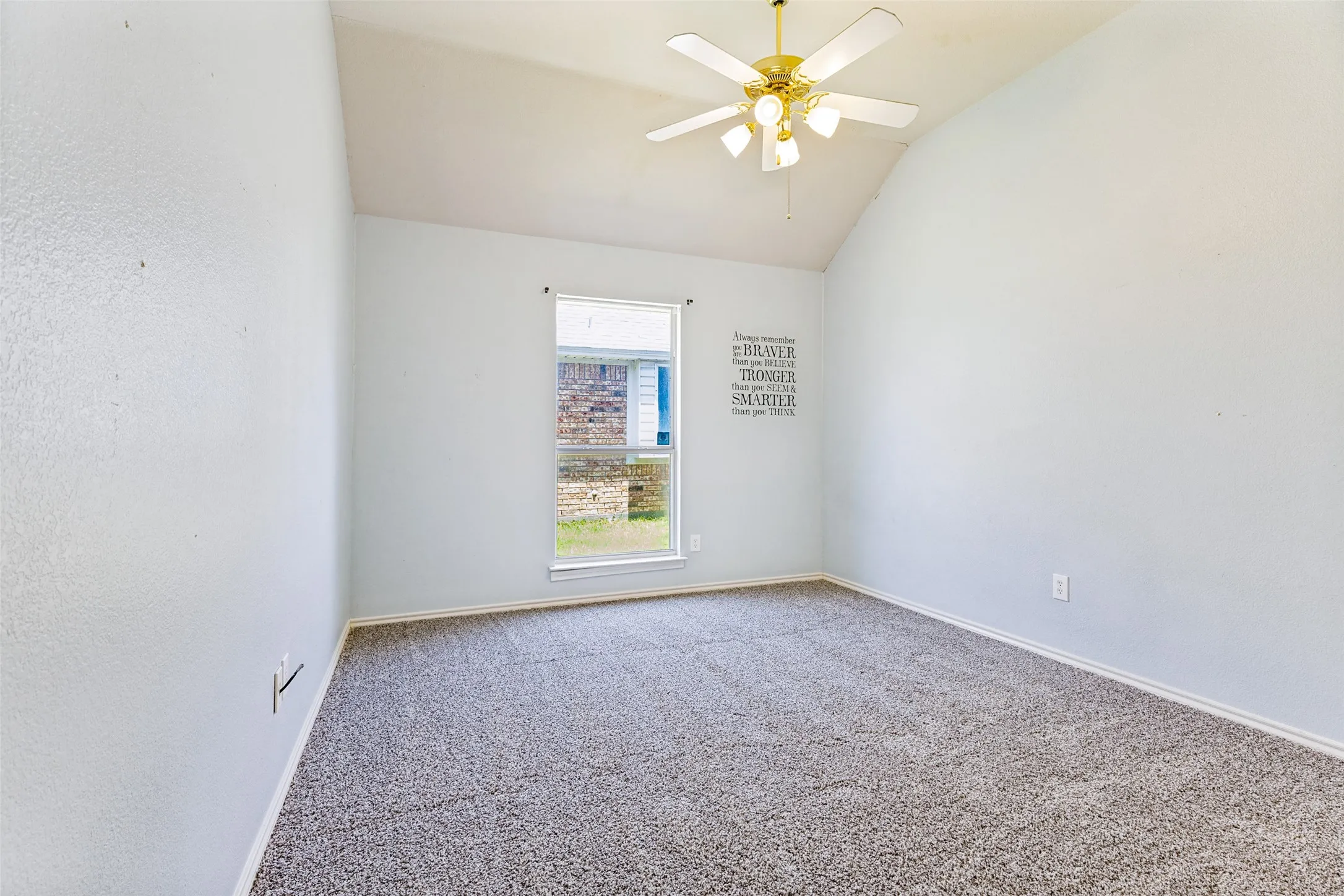 Room featuring a vaulted ceiling with a ceiling fan, a window, and gray flecked carpet flooring