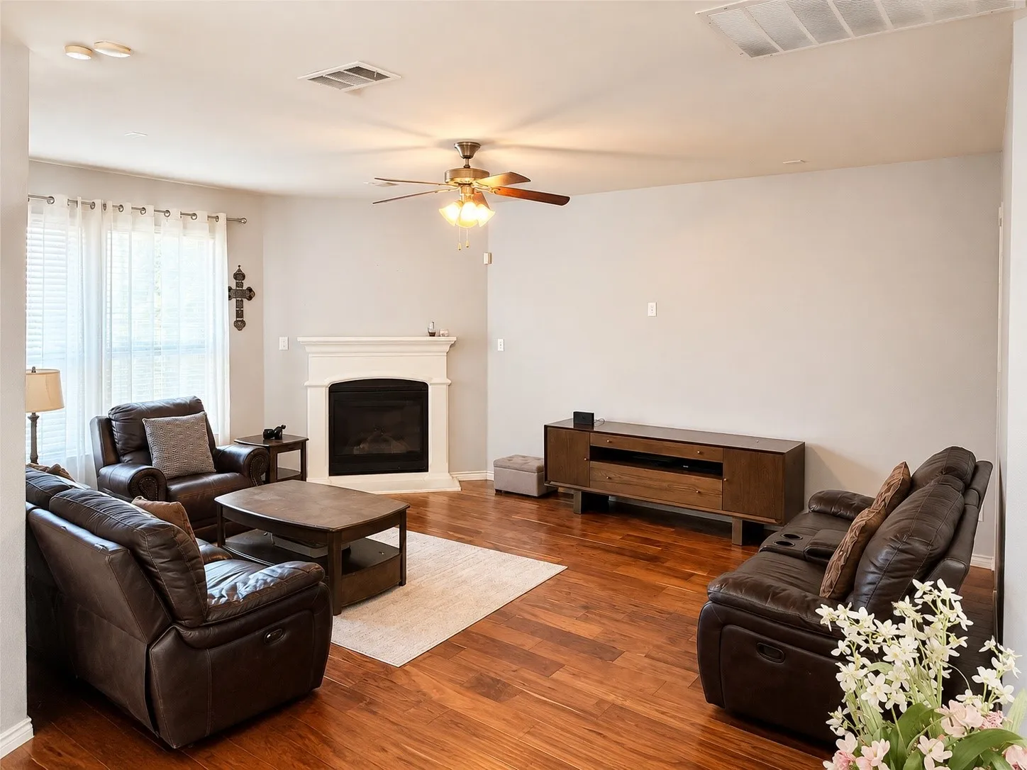 Living room featuring wood-finish flooring and a white mantel fireplace