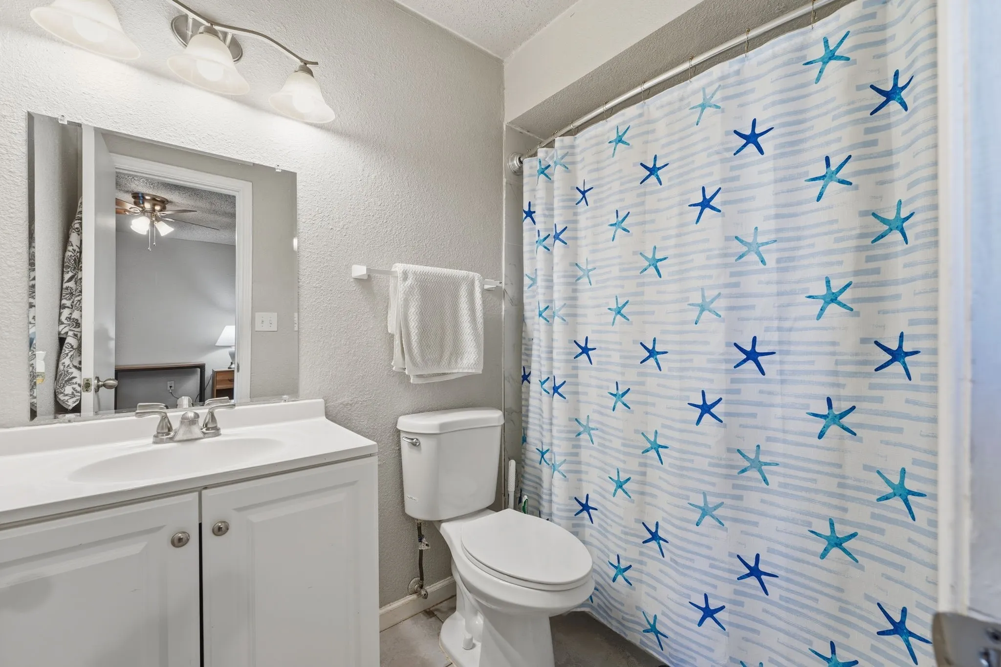 Primary bathroom with updated vanity and shower/tub combination.