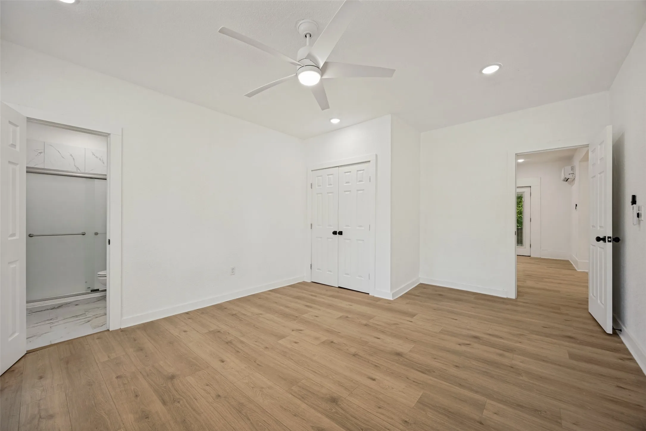 Bright interior space featuring wood-finish flooring, recessed lighting, and a contemporary ceiling fan