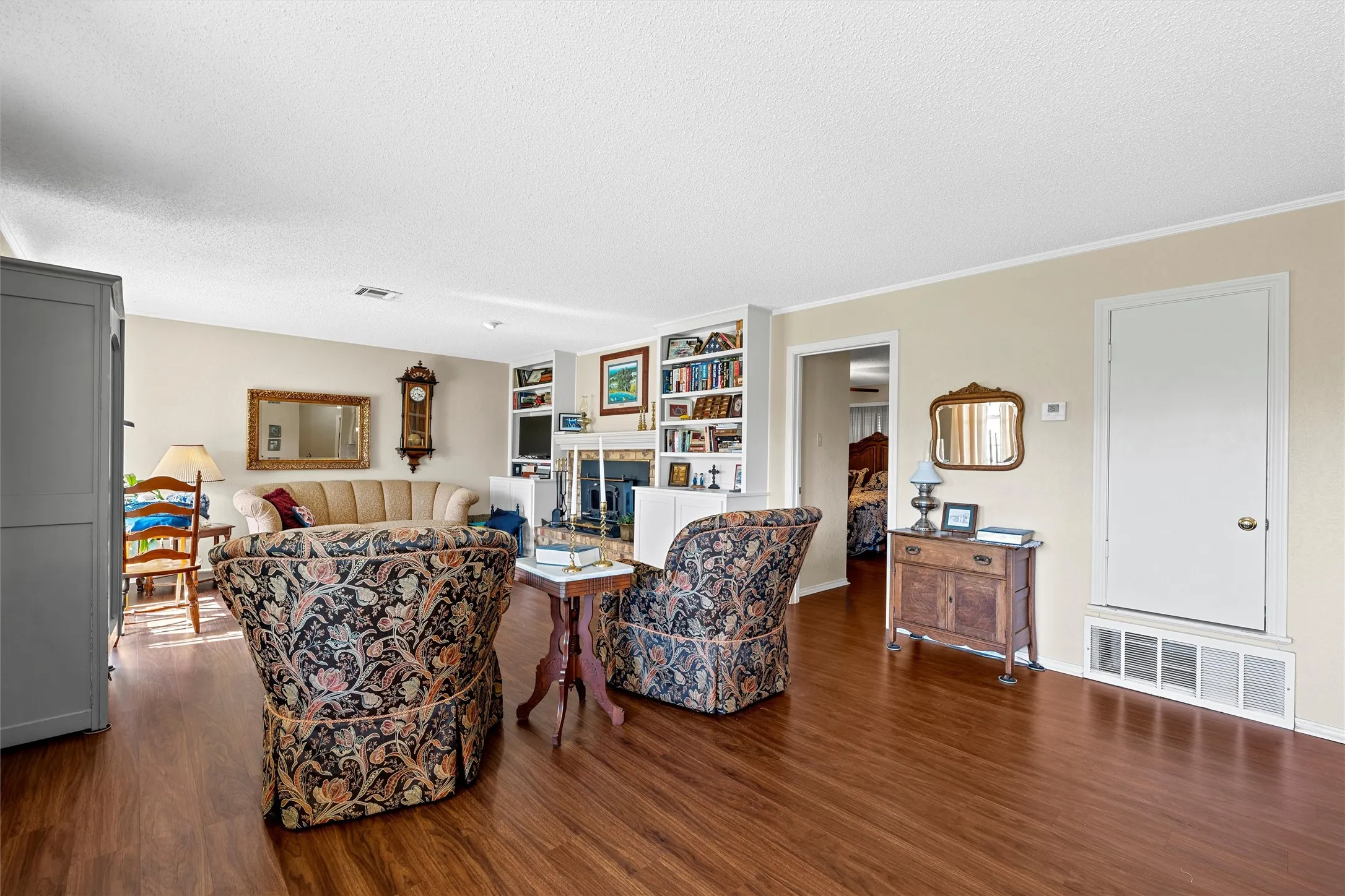 Spacious interior featuring wood-finish flooring, light-toned walls, built-in shelving, and white baseboards