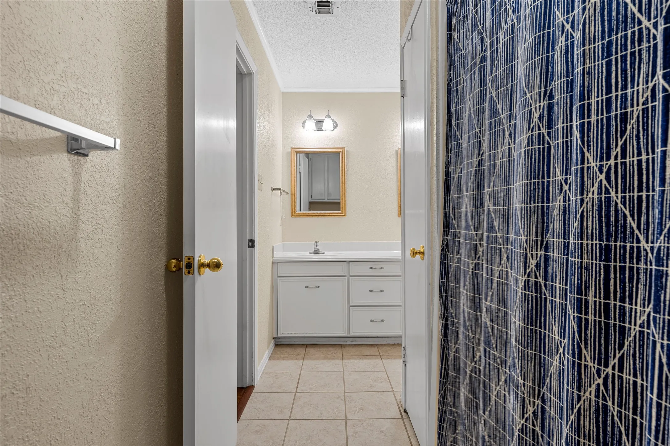 Bathroom vanity featuring a single basin, white countertop, and white cabinetry