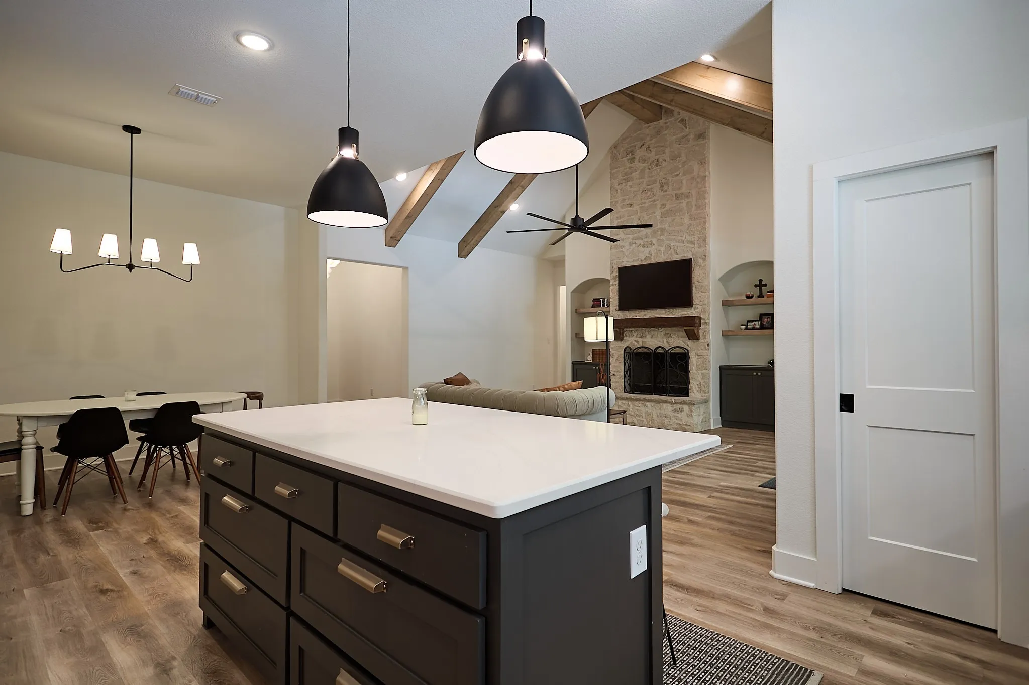 Kitchen island with a white countertop and dark cabinetry featuring gold-tone hardware