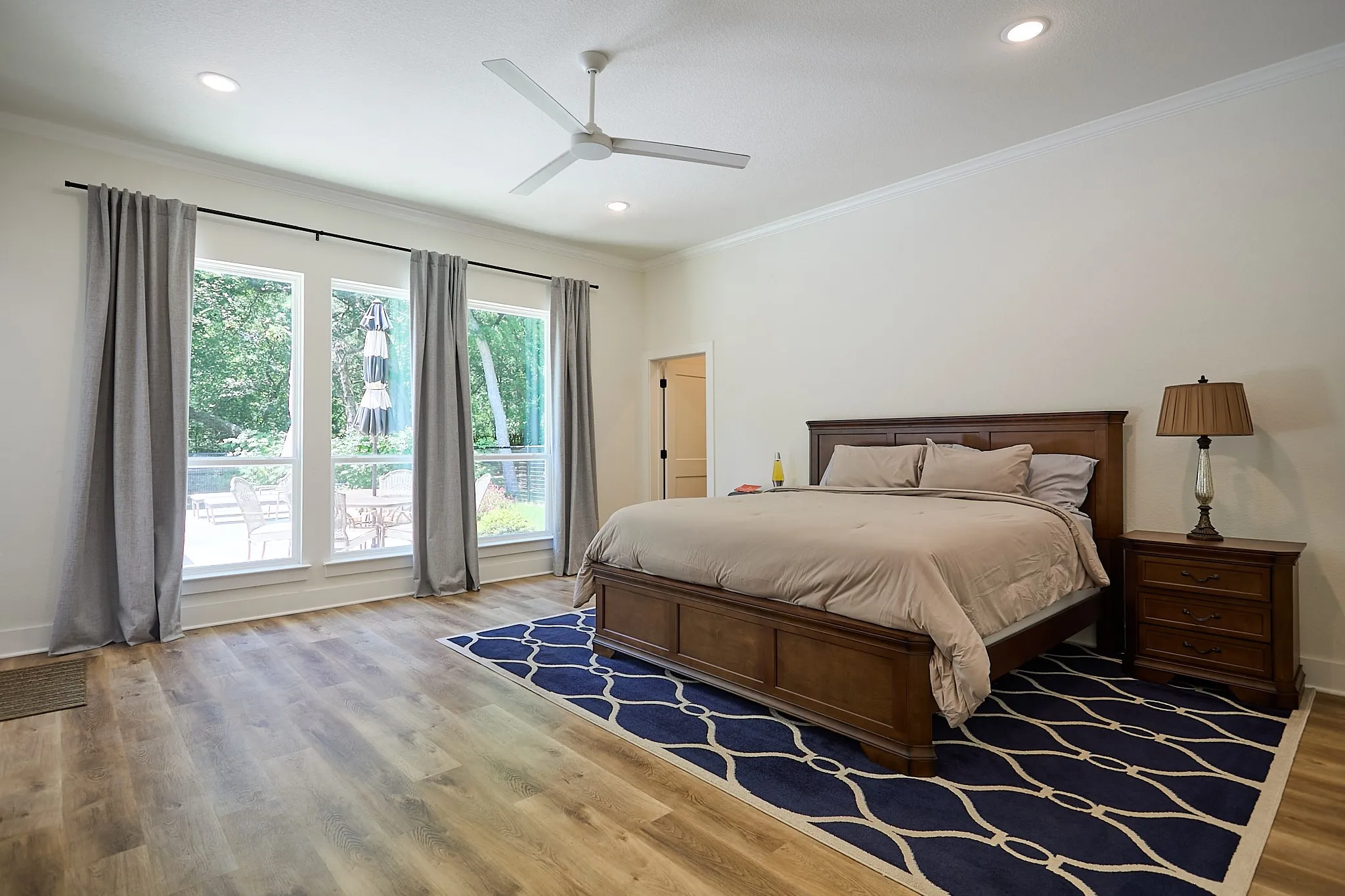 Spacious room featuring wood-finish flooring and a vaulted ceiling with crown molding