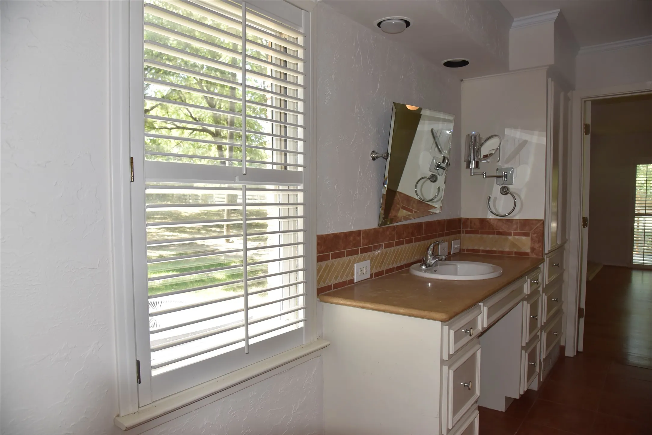 Vanity area featuring a built-in sink, stone-finish countertop, and tile backsplash