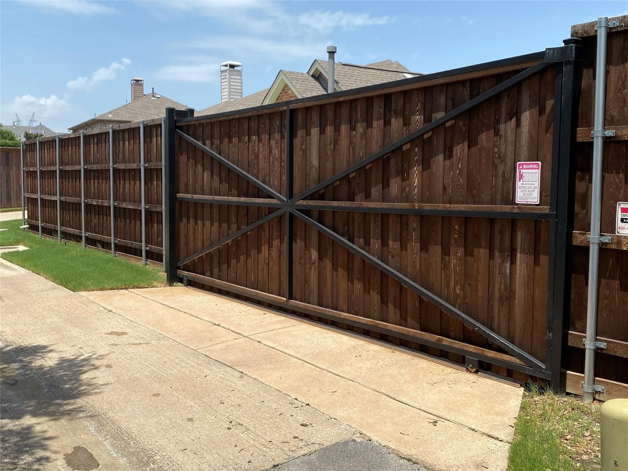 Solid wood fencing with a sturdy metal frame and cross-brace detailing provides privacy