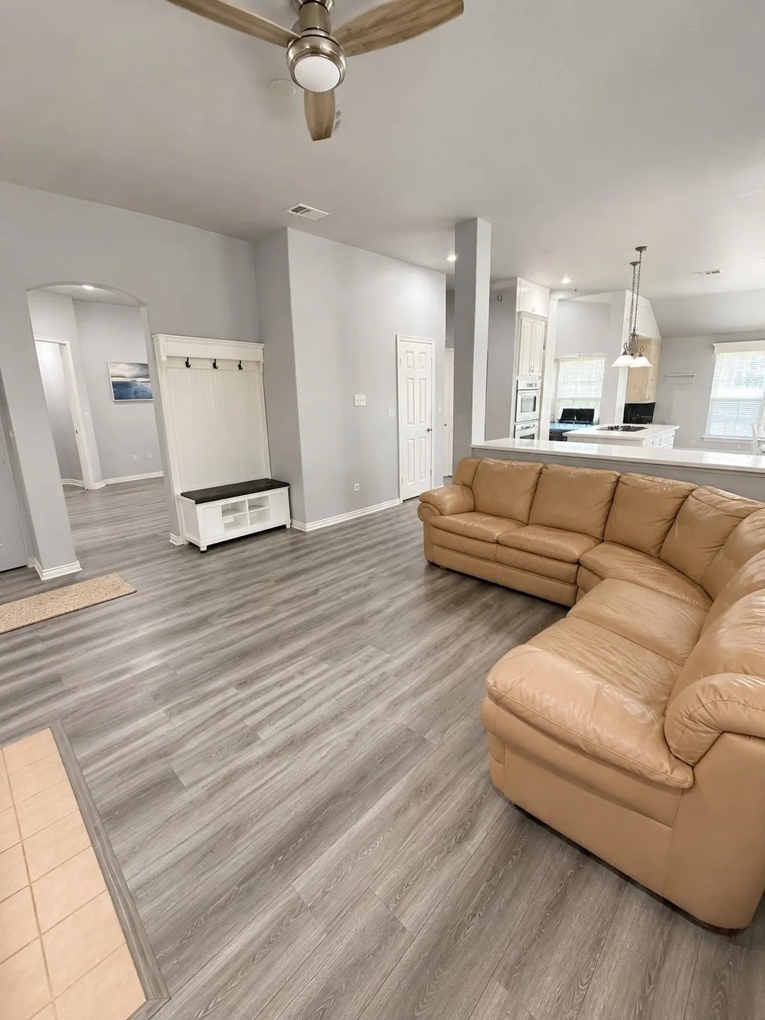 Open-concept living space with wood-finish flooring, a contemporary ceiling fan, and recessed lighting