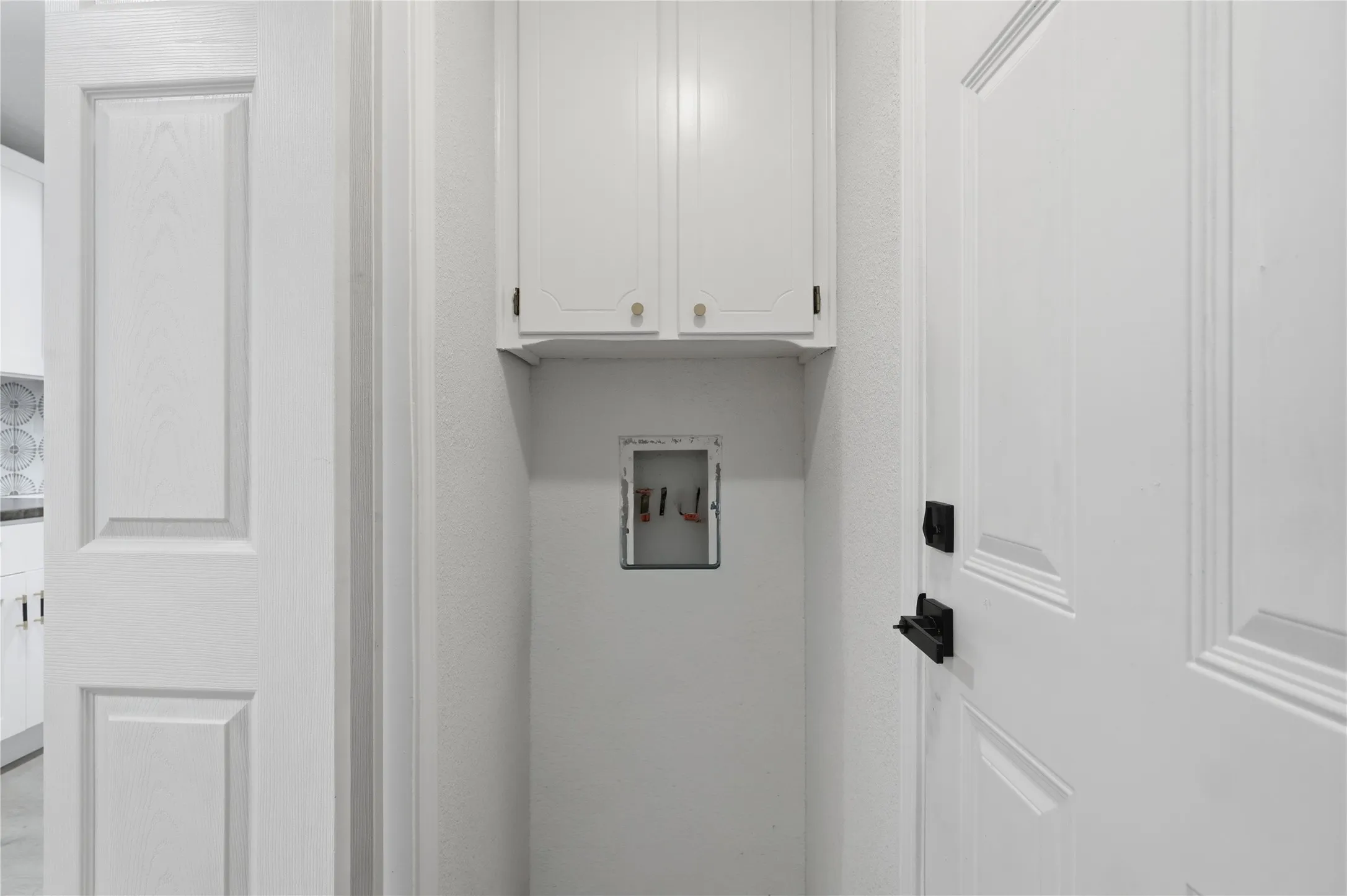 Dedicated laundry nook featuring upper cabinetry and utility hookups