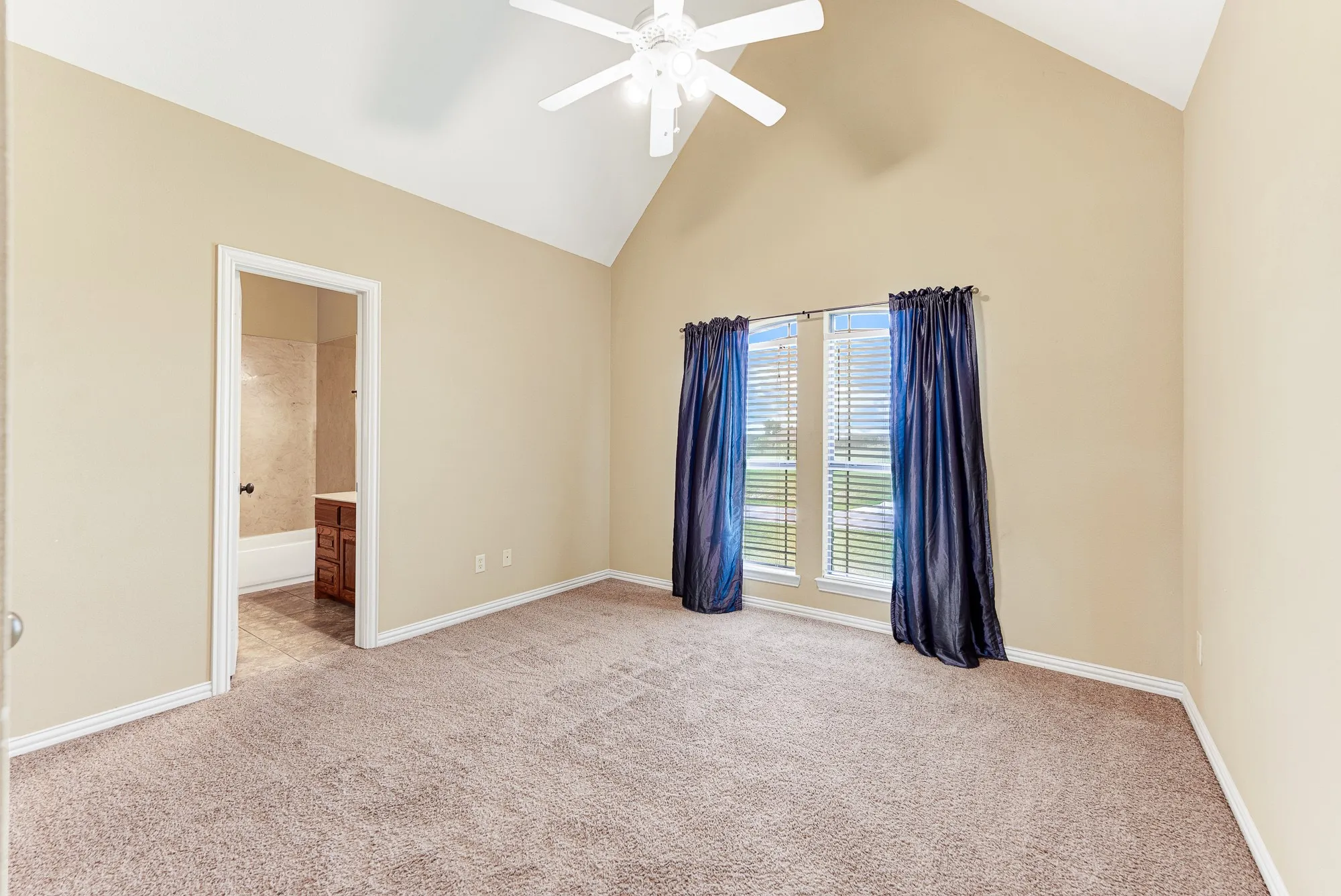 A pair of tall, side-by-side windows filters soft daylight across the expansive floor plan. It serves as a beautiful backdrop for a relaxing afternoon retreat spent reading or just enjoying the view.