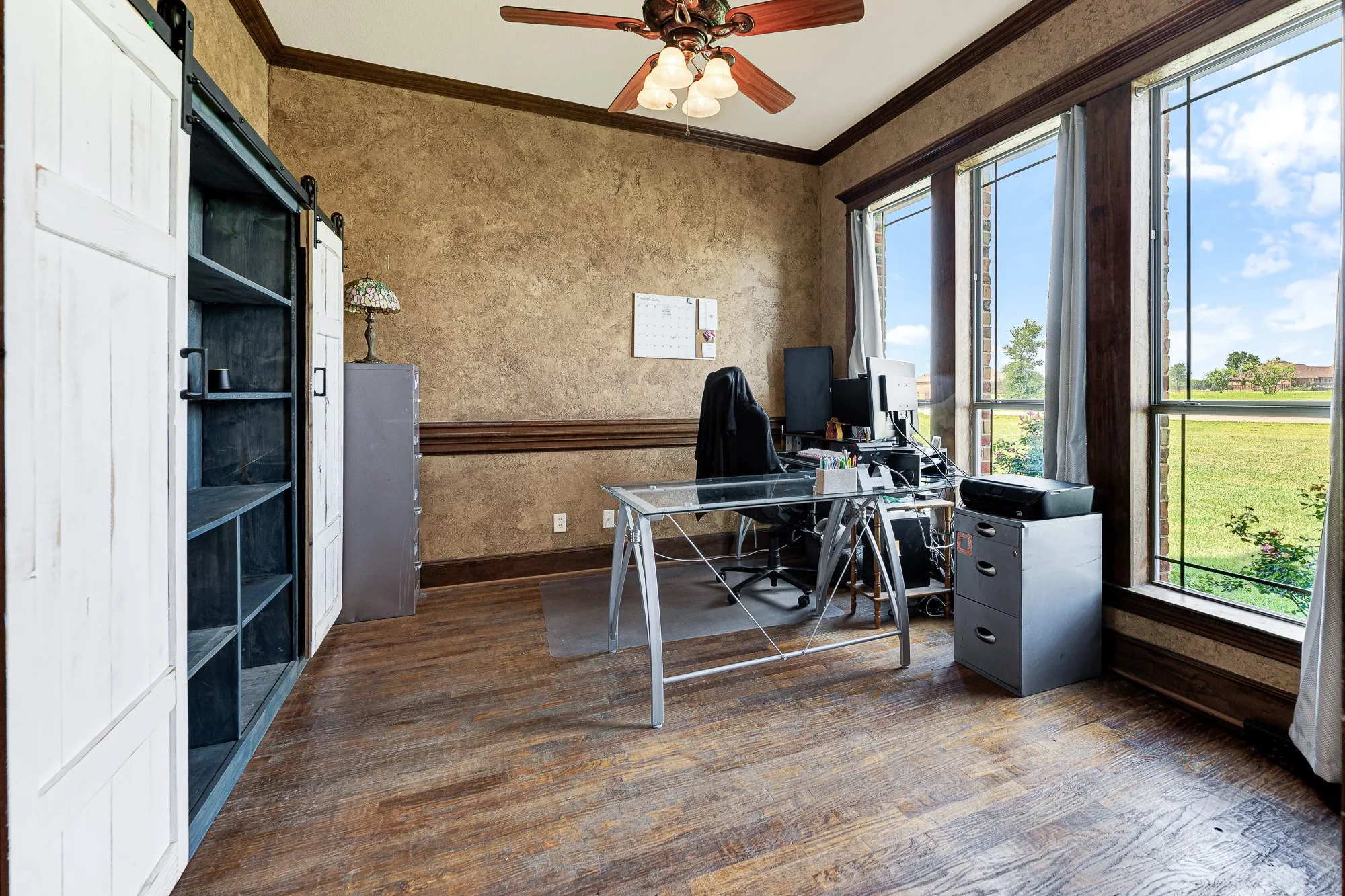 Generous windows flood the space with clear daylight, highlighting the rich, earthy texture of the walls. Imagine catching fresh inspiration from the sweeping green views during a quiet midday pause in your productive workday.