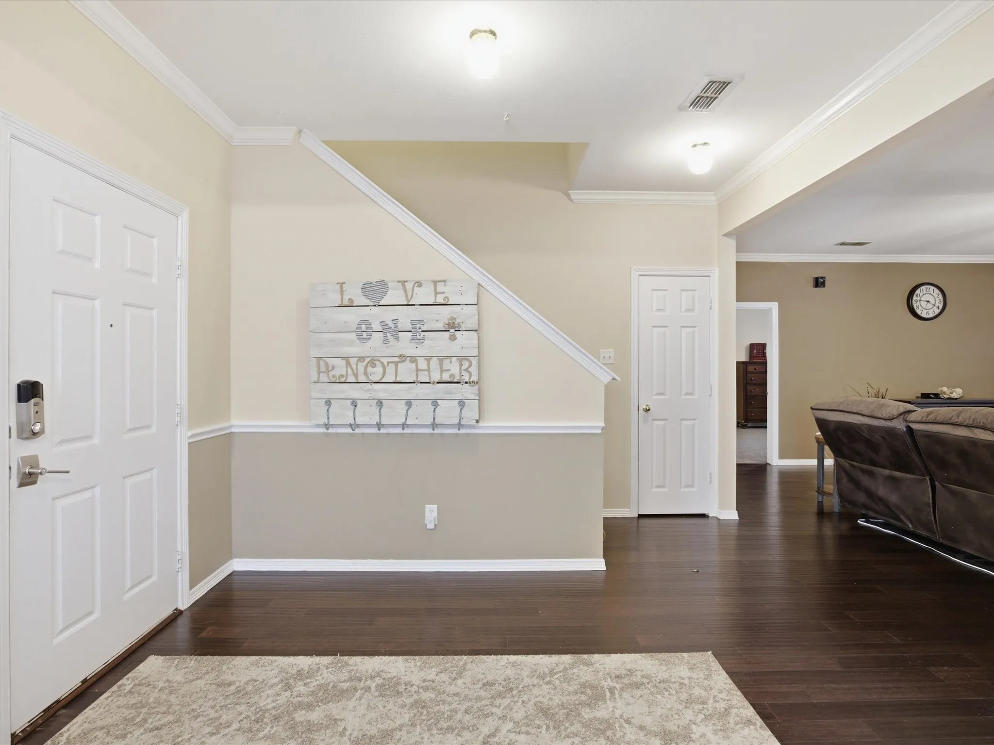 Welcoming entry with dark wood-finish flooring, white baseboards, and two-tone wall treatment