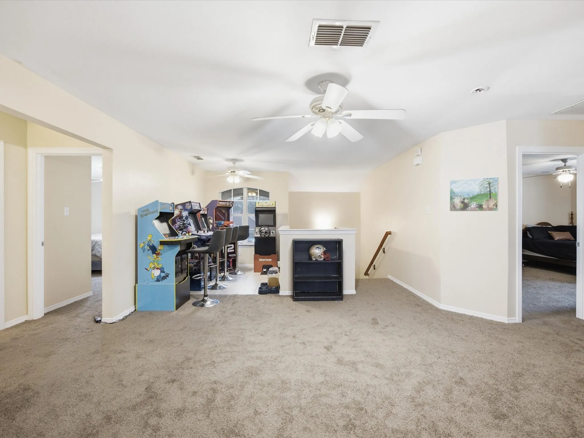 Spacious Game room featuring neutral carpeting, a ceiling fan with integrated lighting, and multiple distinct activity zones