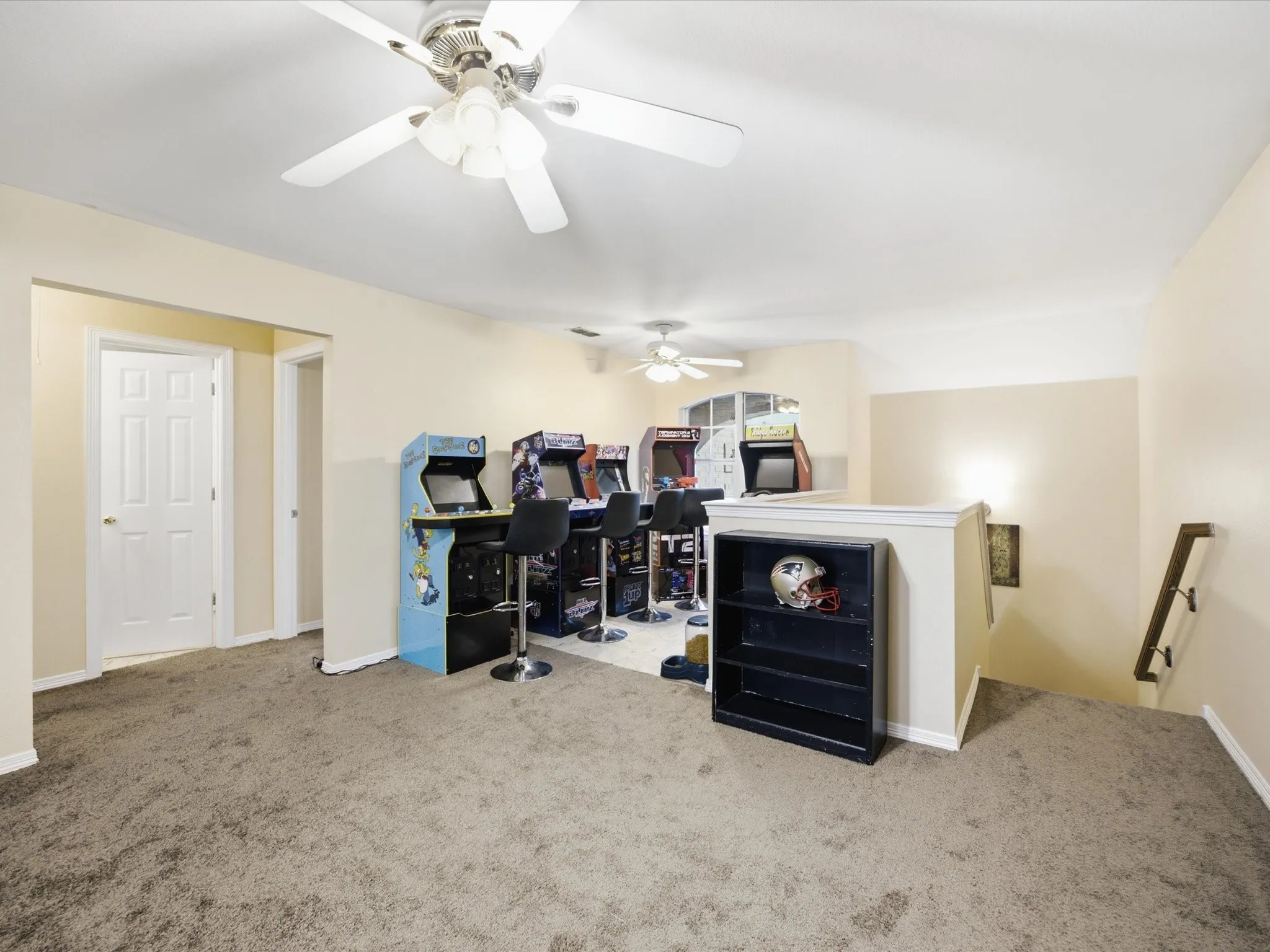 Spacious Game room featuring neutral carpeting, a ceiling fan with integrated lighting, and multiple distinct activity zones