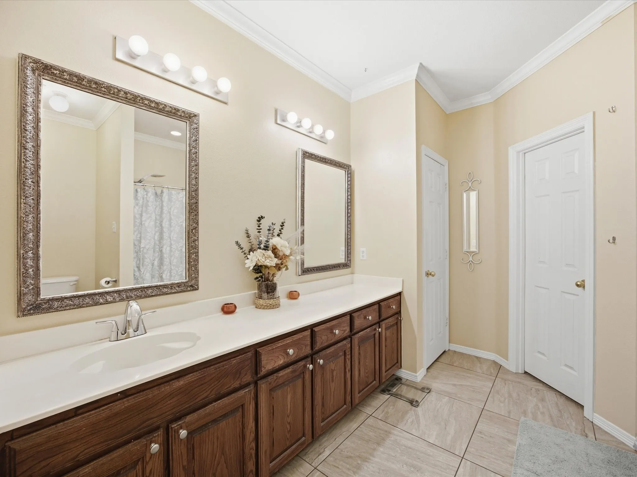 Dual sink vanity with wood-finish cabinetry and white countertops