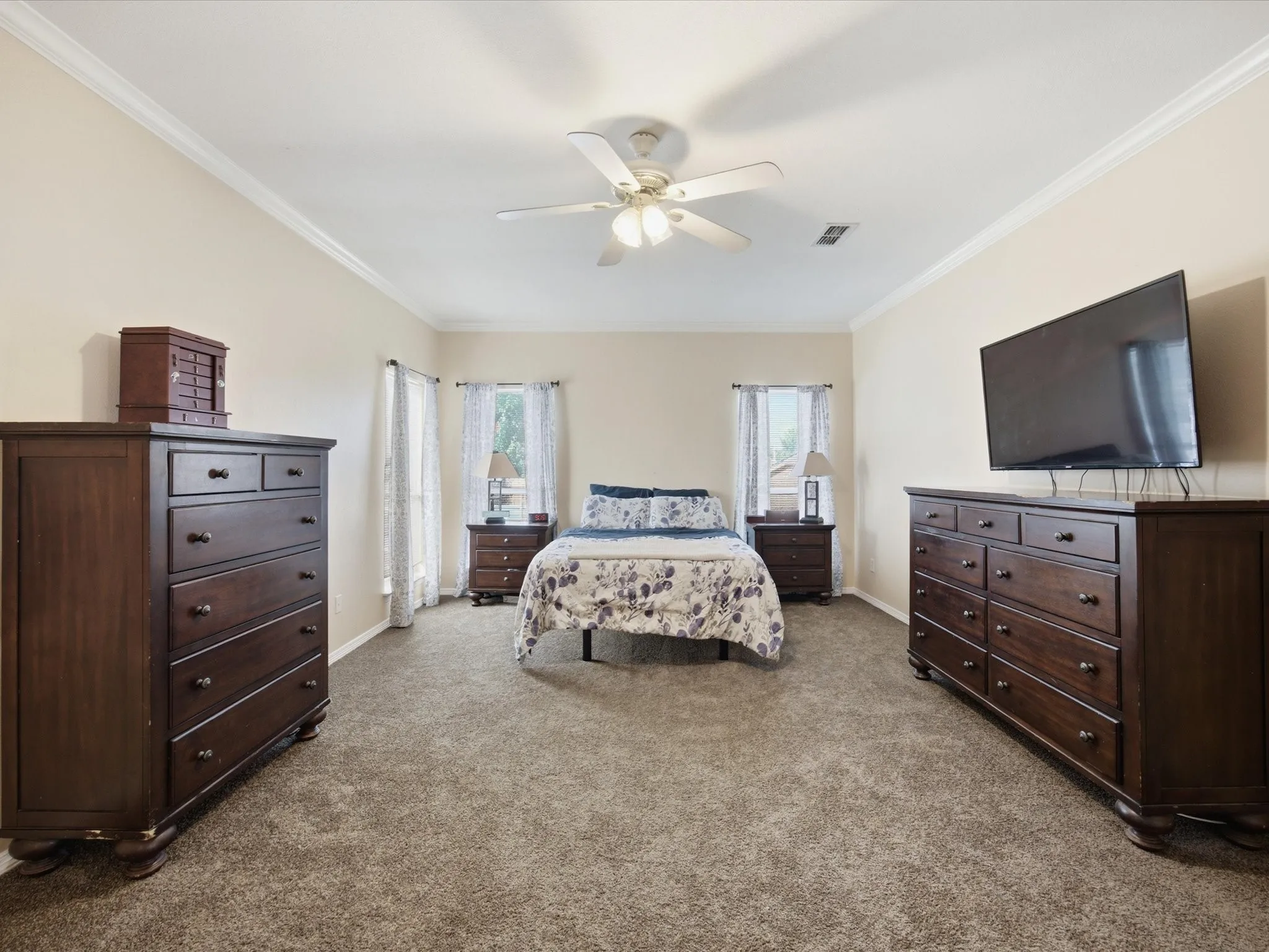 Neutral-toned Primary bedroom featuring wall-to-wall carpeting and crown molding