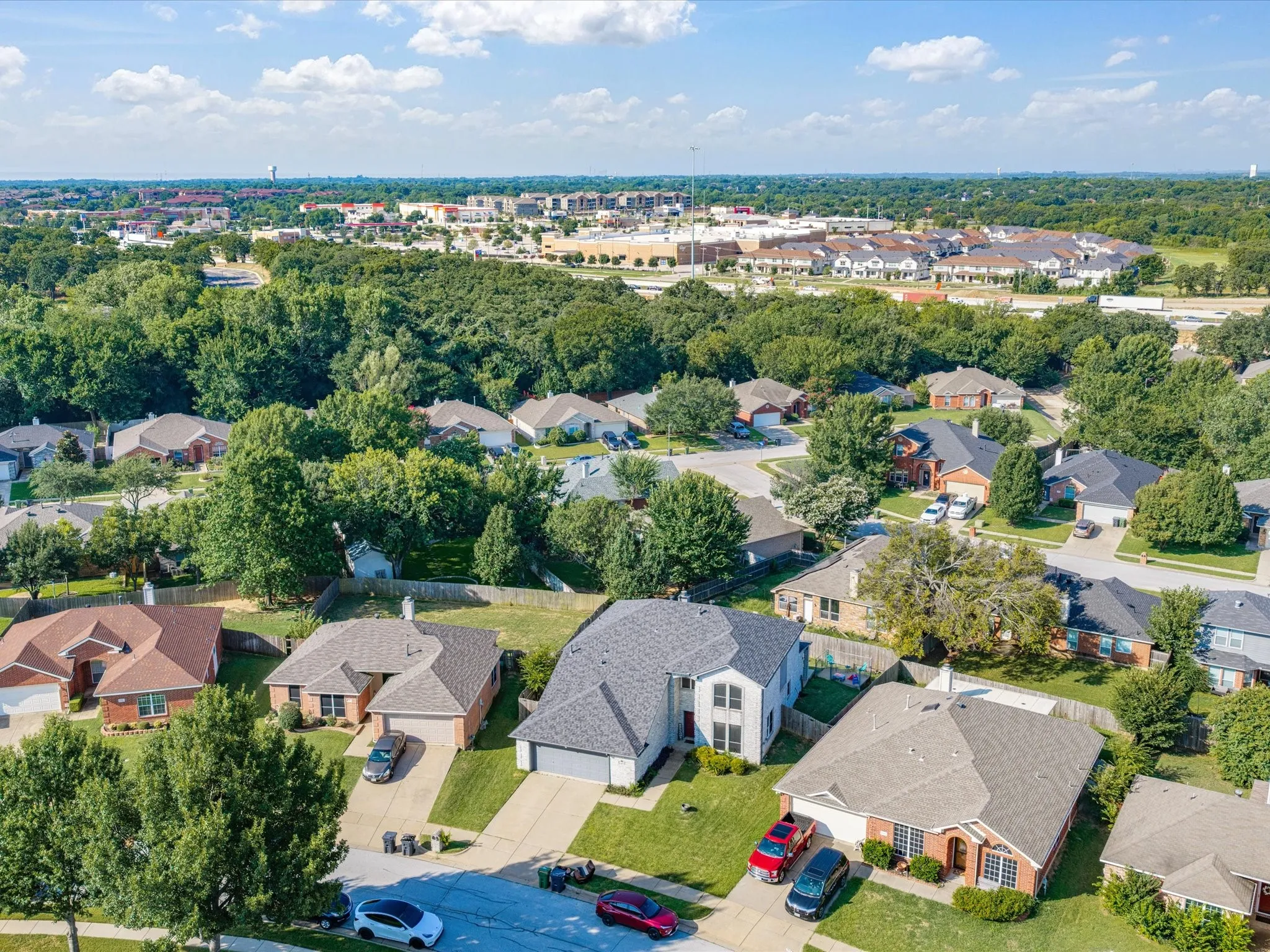 Residential neighborhood featuring a variety of single-family homes, mature trees, and paved streets